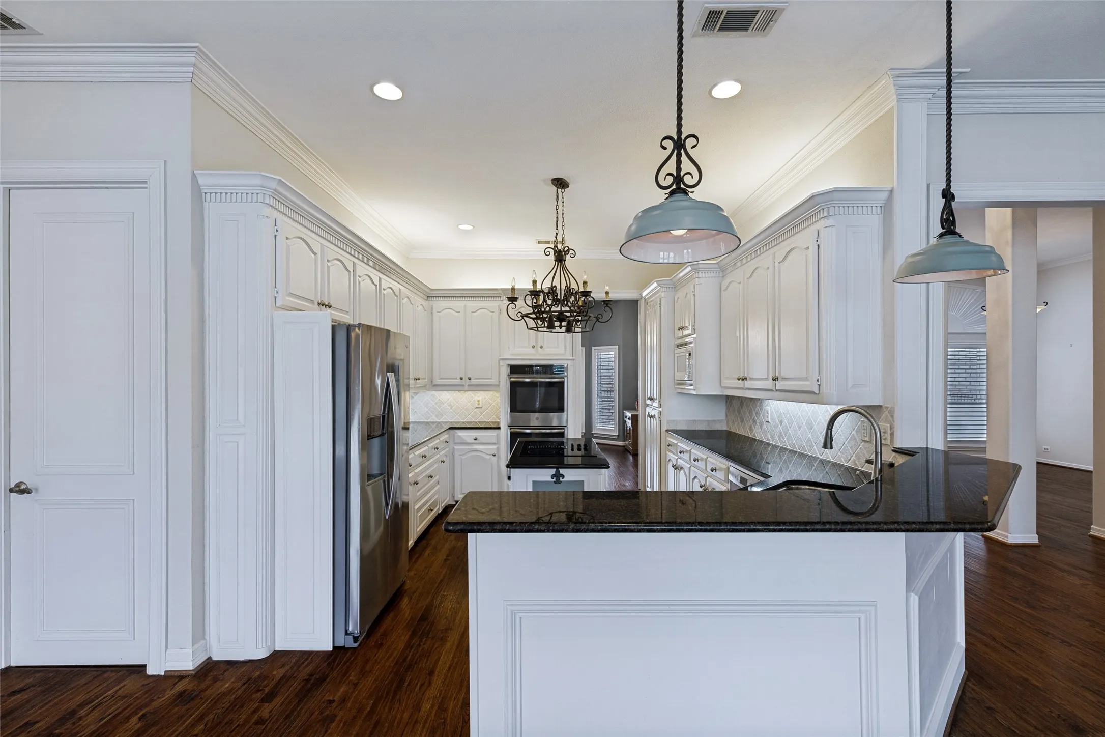 Open concept kitchen with Granite countertops, a spacious breakfast bar for friends to gather around! Hardwoods floors, cool lighting and access to the formal Dining too.