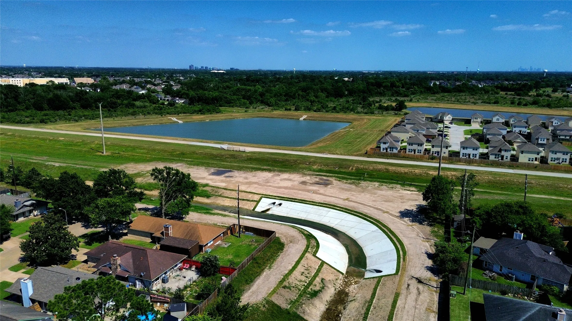 Aerial perspective showcasing multiple residential structures, a large body of water, and surrounding green spaces