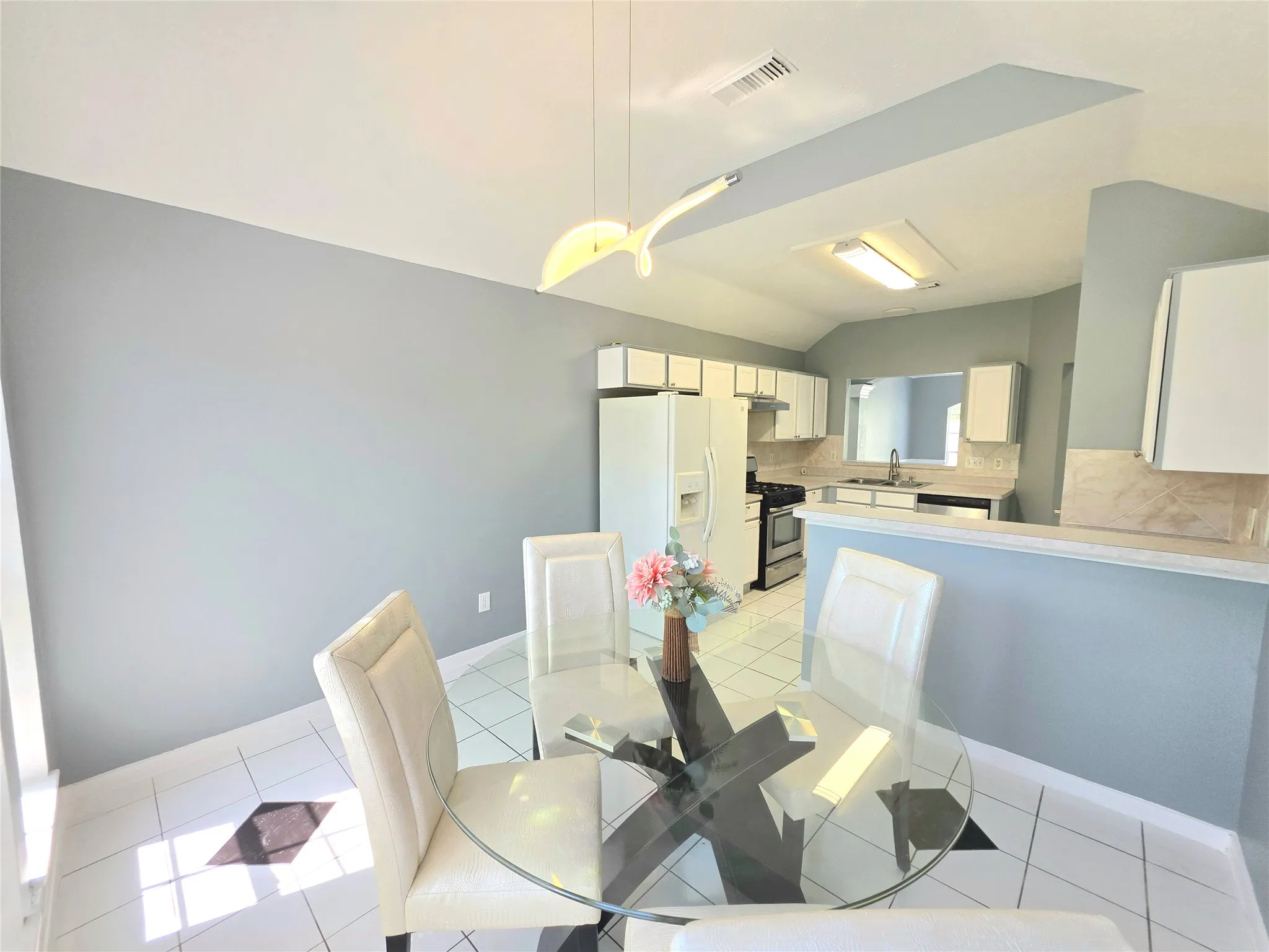 Kitchen featuring white cabinetry, a pass-through window, and a breakfast bar