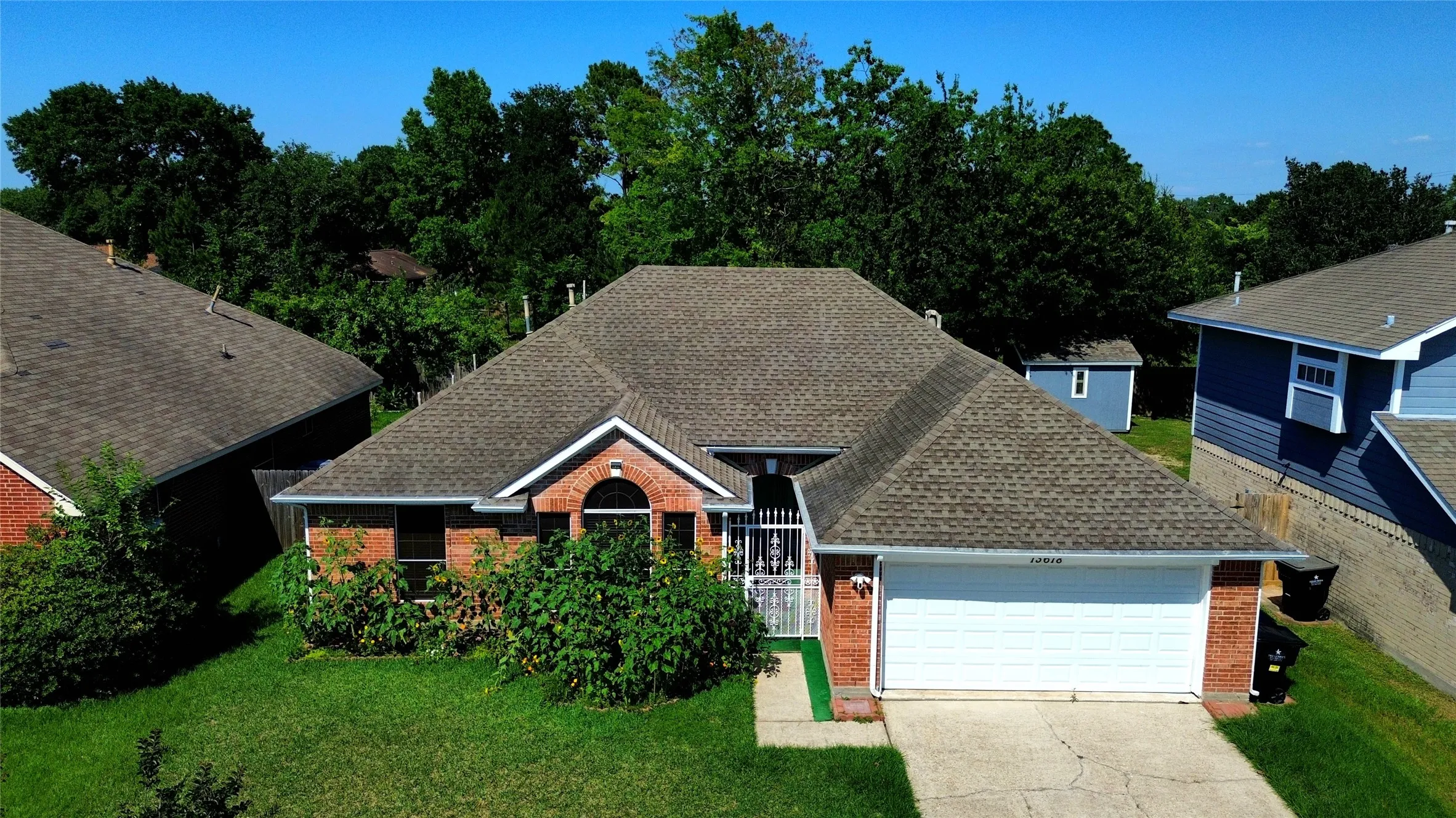 Brick exterior with a peaked roofline, an arched entry, and an integrated two-car garage