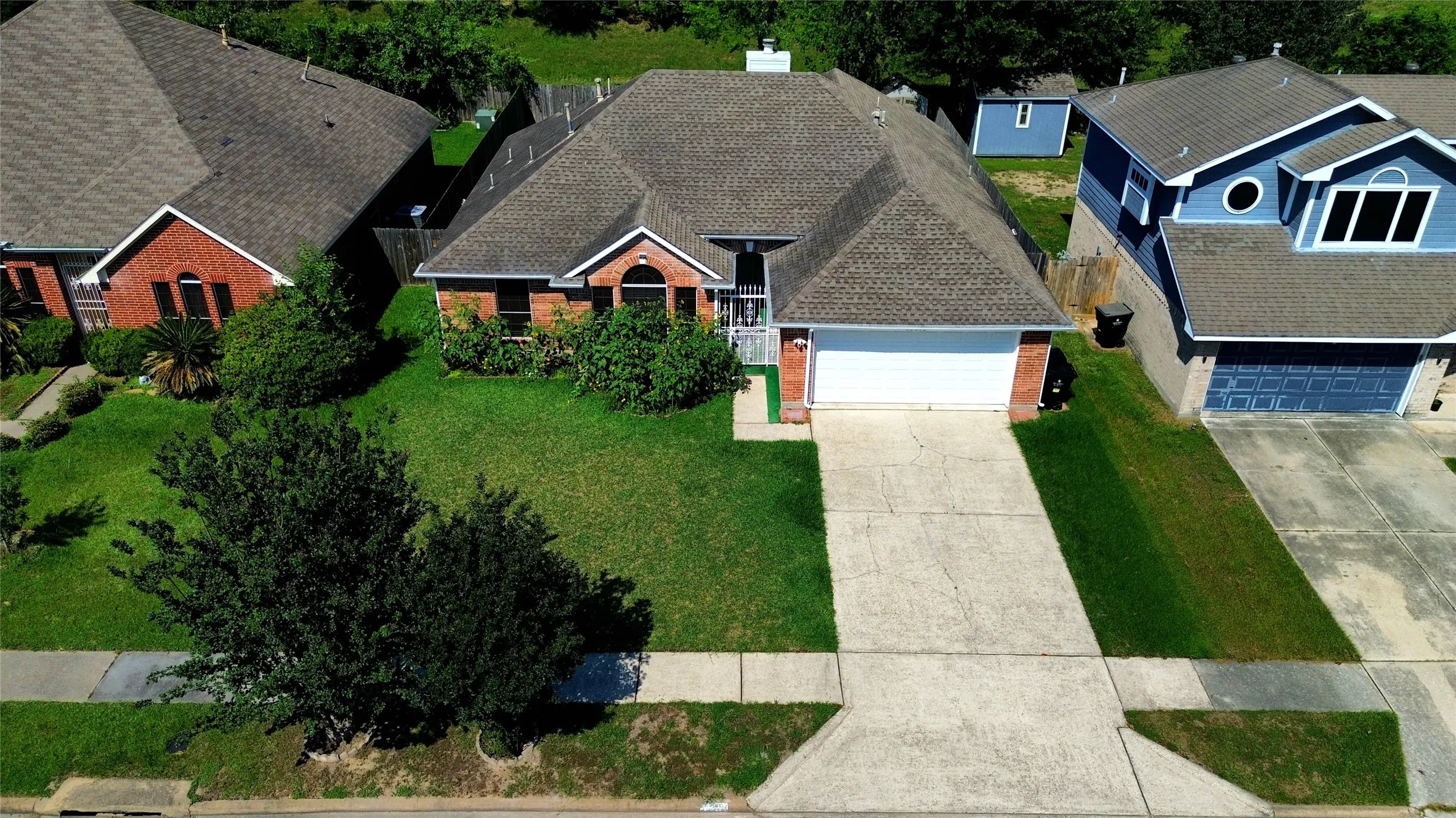 Single-story residence featuring a gray shingle roof, brick facade accents, and an attached two-car garage