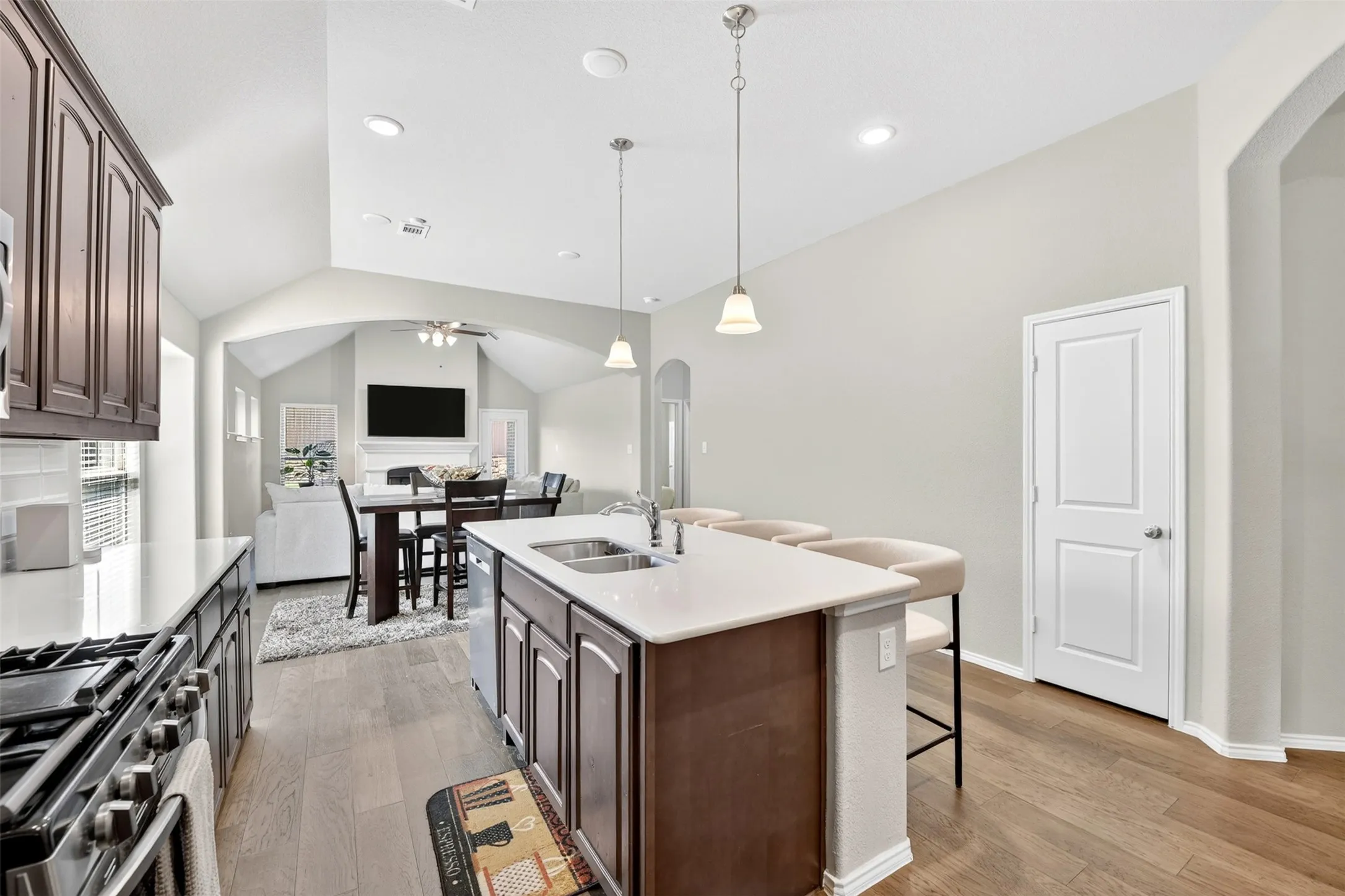 Kitchen island with integrated sink, pendant lighting, and seating space