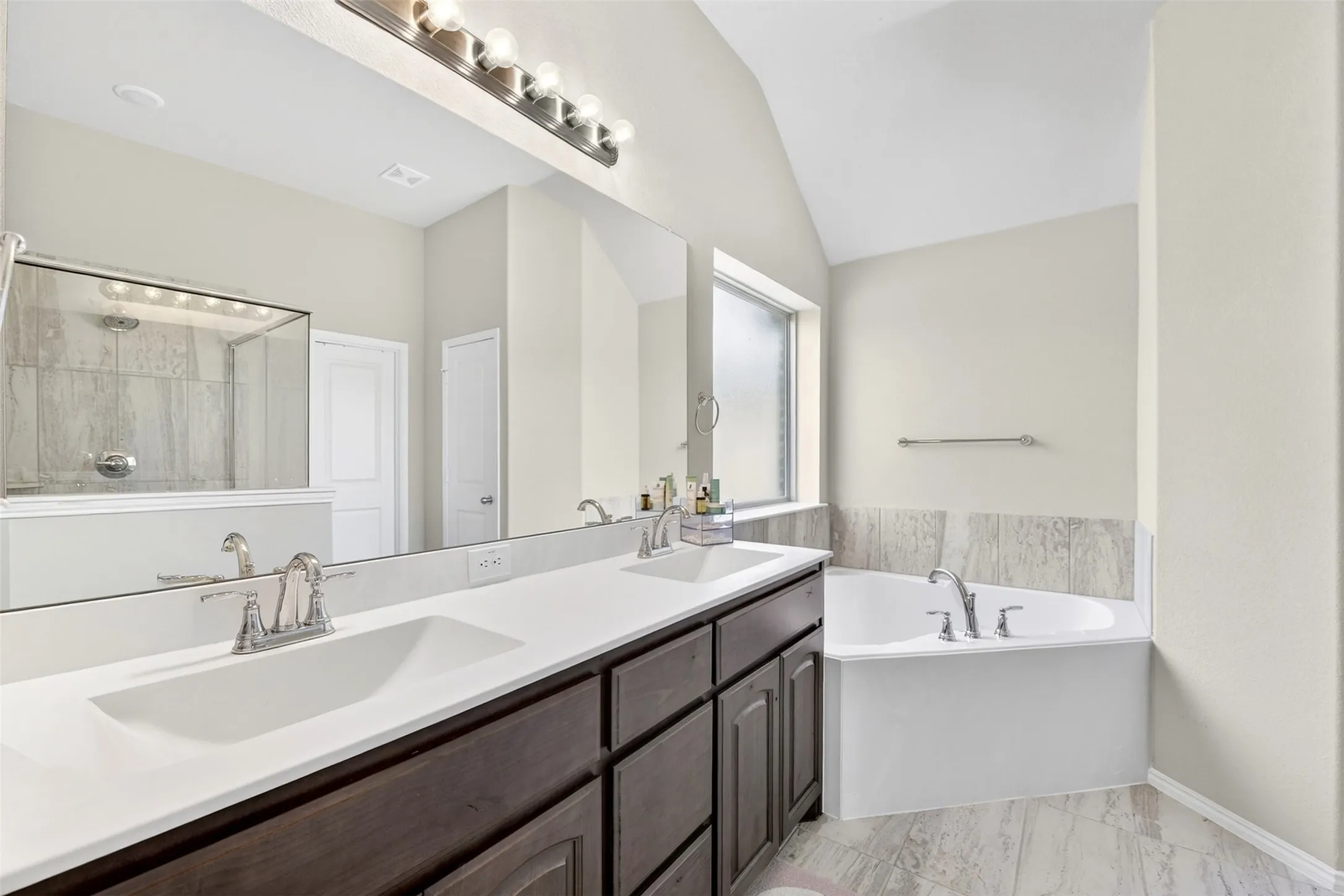 Dual vanity with integrated sinks and white countertops, featuring dark wood-finish cabinetry