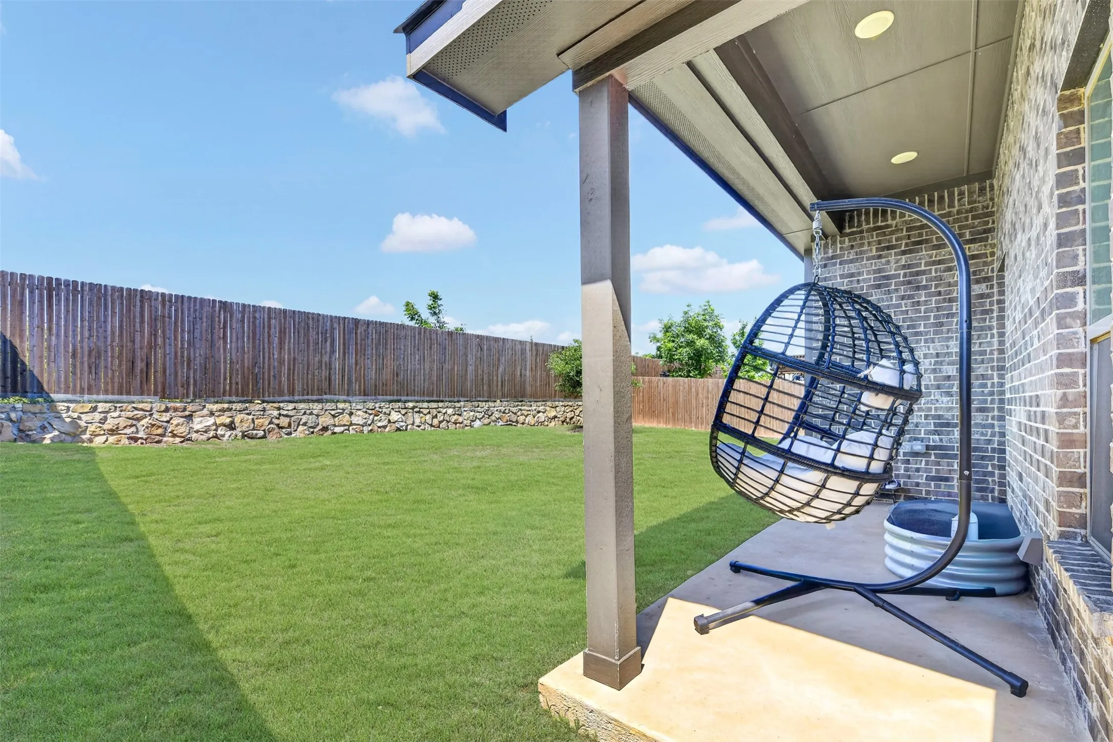 Covered patio with recessed lighting, brick exterior, and concrete flooring