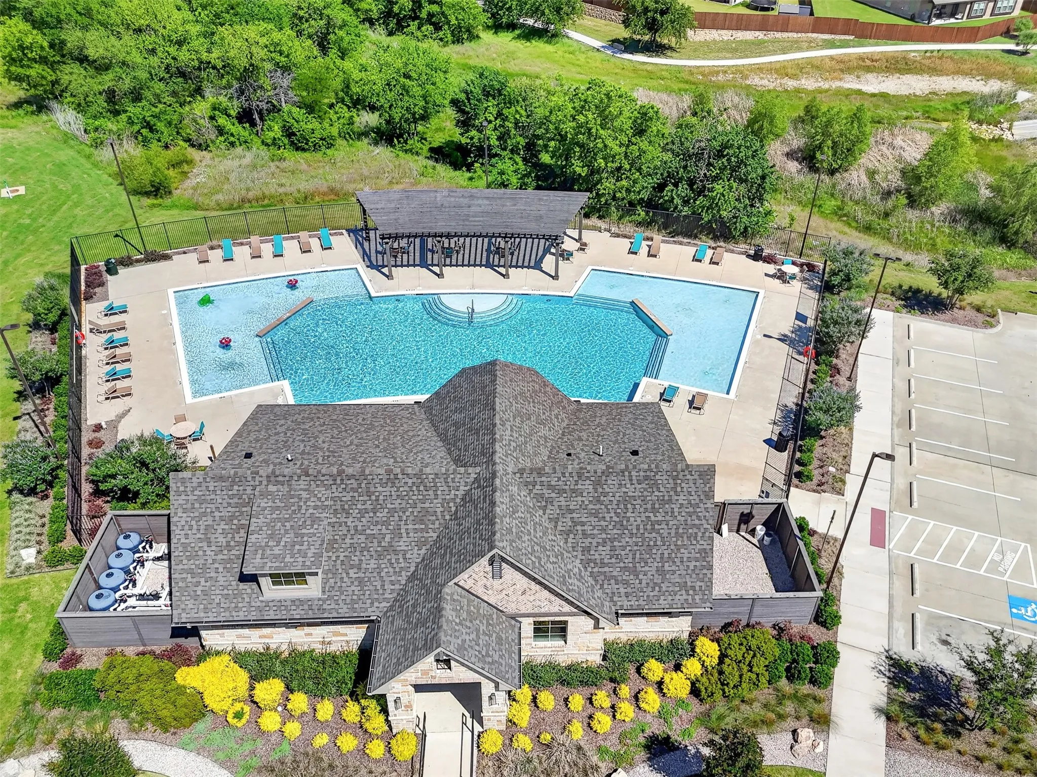 Community swimming pool with sun shelf and a shaded pergola