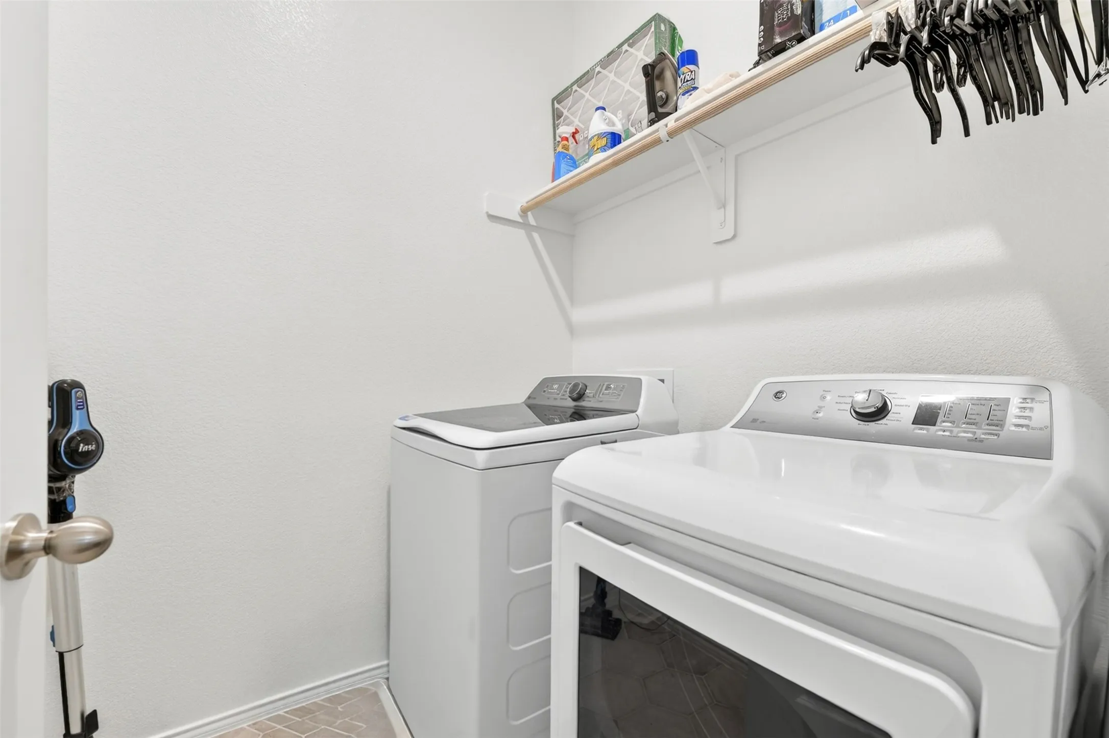 Dedicated laundry area featuring a shelf with hanging rod