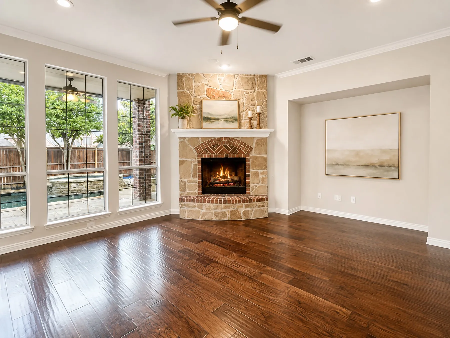 Spacious family room corner stone fireplace with a brick firebox detailing.