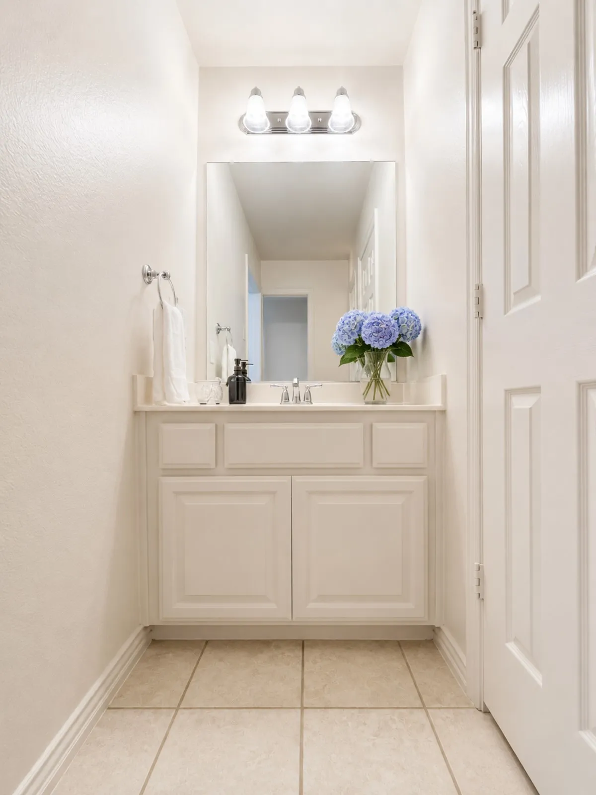 Jack and Jill vanity area featuring a white cabinet with paneling, a light countertop, and a rectangular mirror