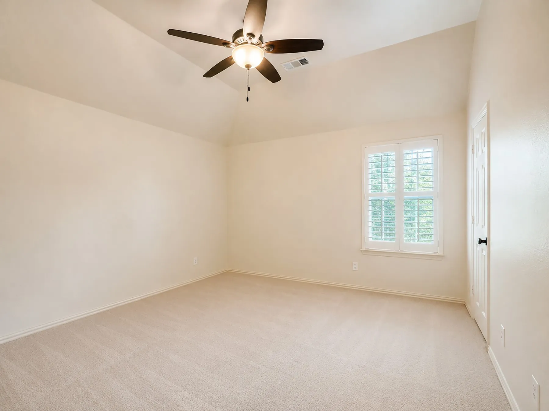 Bedrooms upstairs are oversized and provide a comfortable retreat. The room featuring vaulted ceilings, neutral carpet flooring, and a ceiling fan with integrated lighting, as well as walk in closet and plantation shutters.