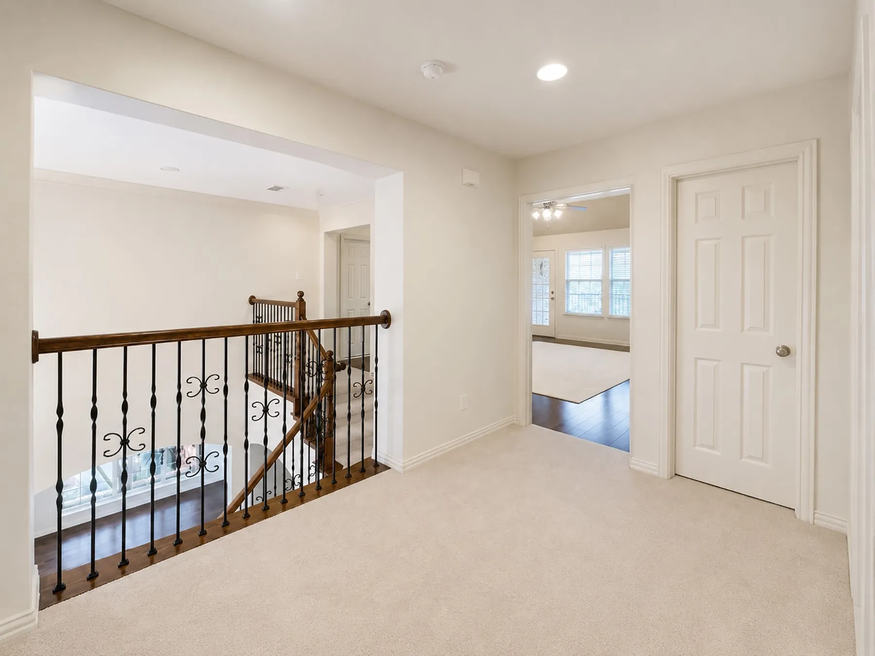 Upper-level landing featuring light-toned carpeting and recessed lighting