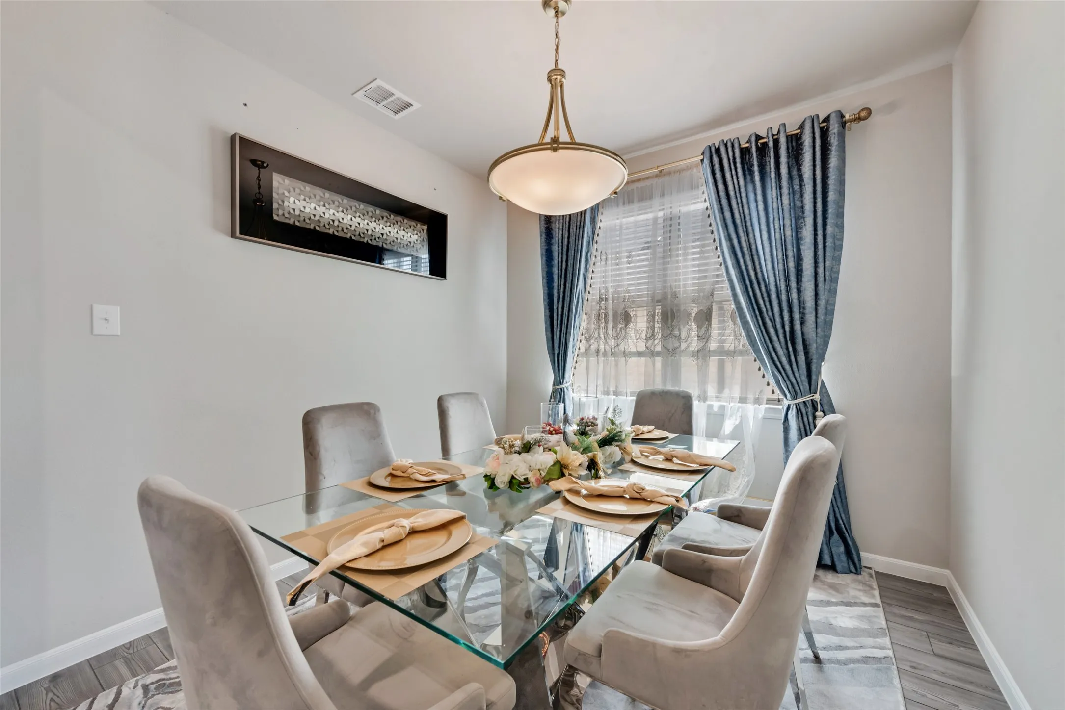 Dining space with visible vents, baseboards, and wood finished floors