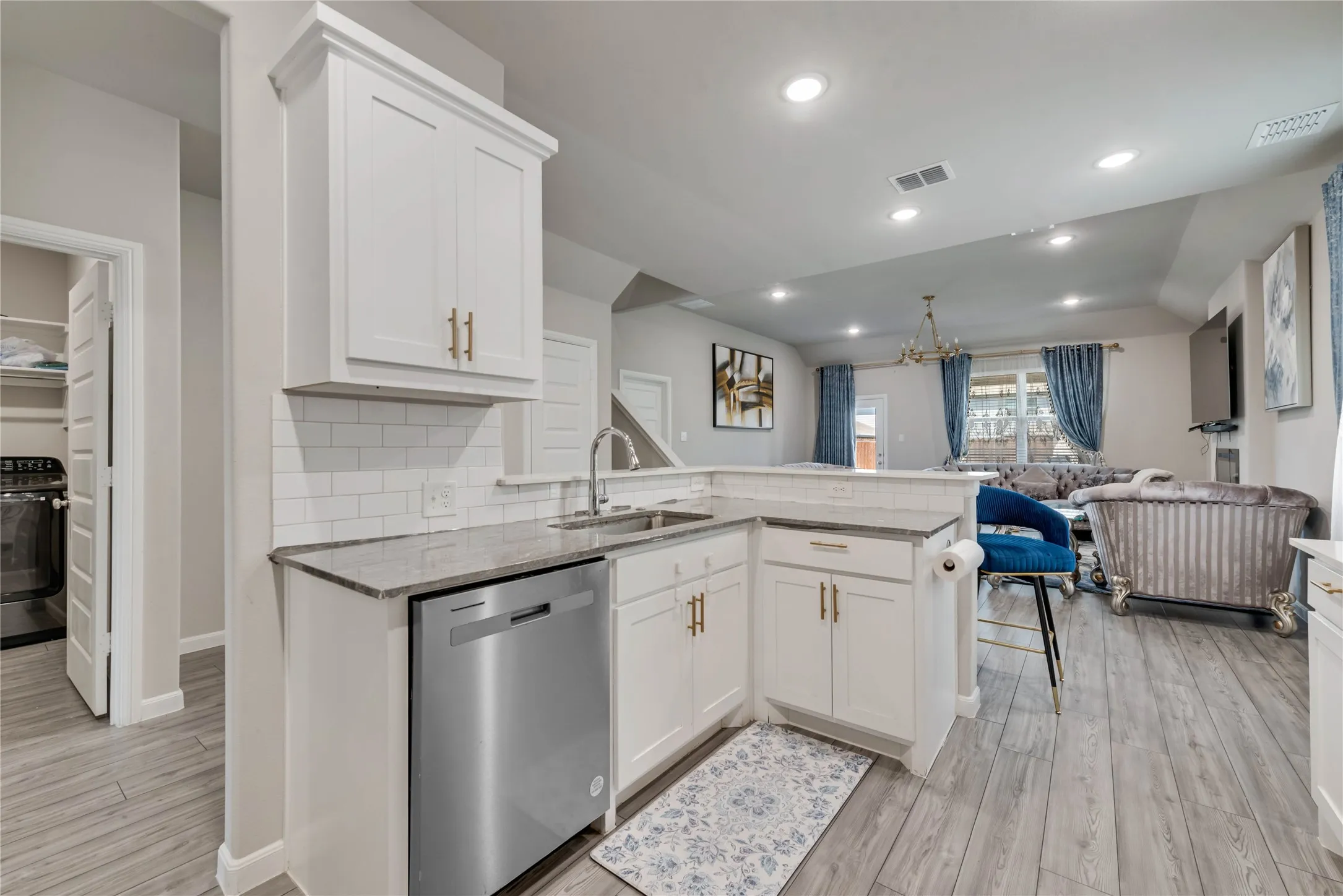 Kitchen featuring visible vents, a sink, open floor plan, stainless steel dishwasher, and range