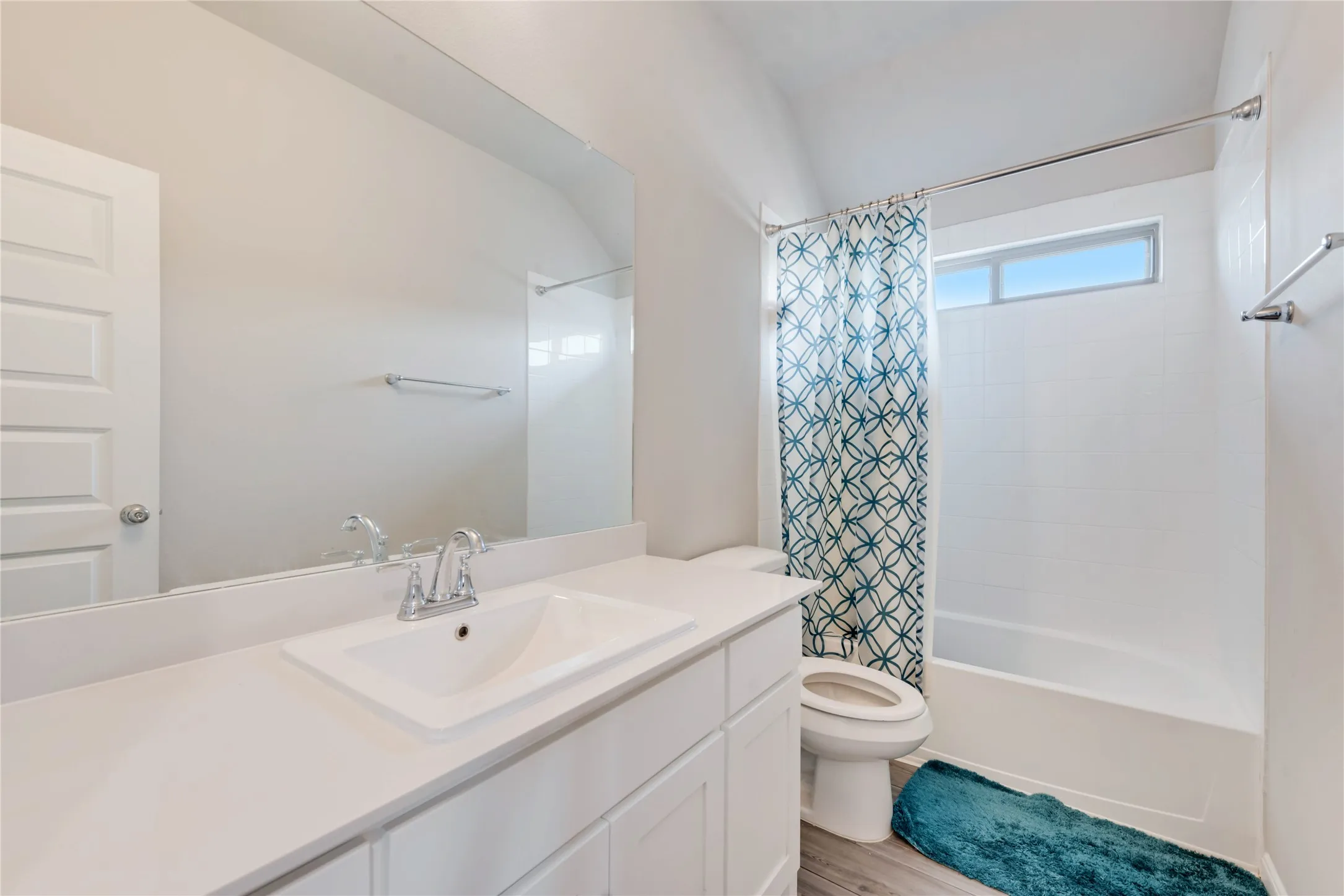 Bathroom with toilet, shower / bath combo with shower curtain, vanity, and wood finished floors