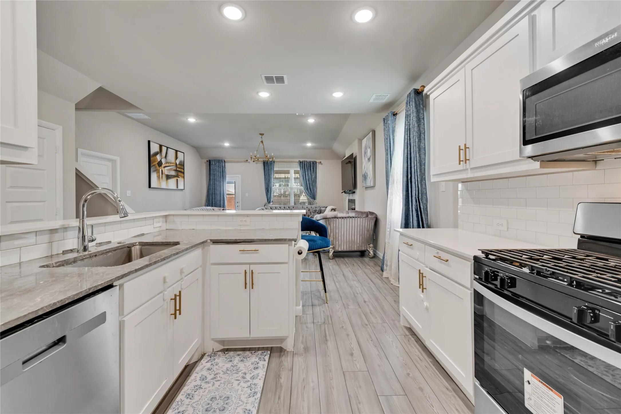 Kitchen featuring tasteful backsplash, recessed lighting, visible vents, stainless steel appliances, and a sink