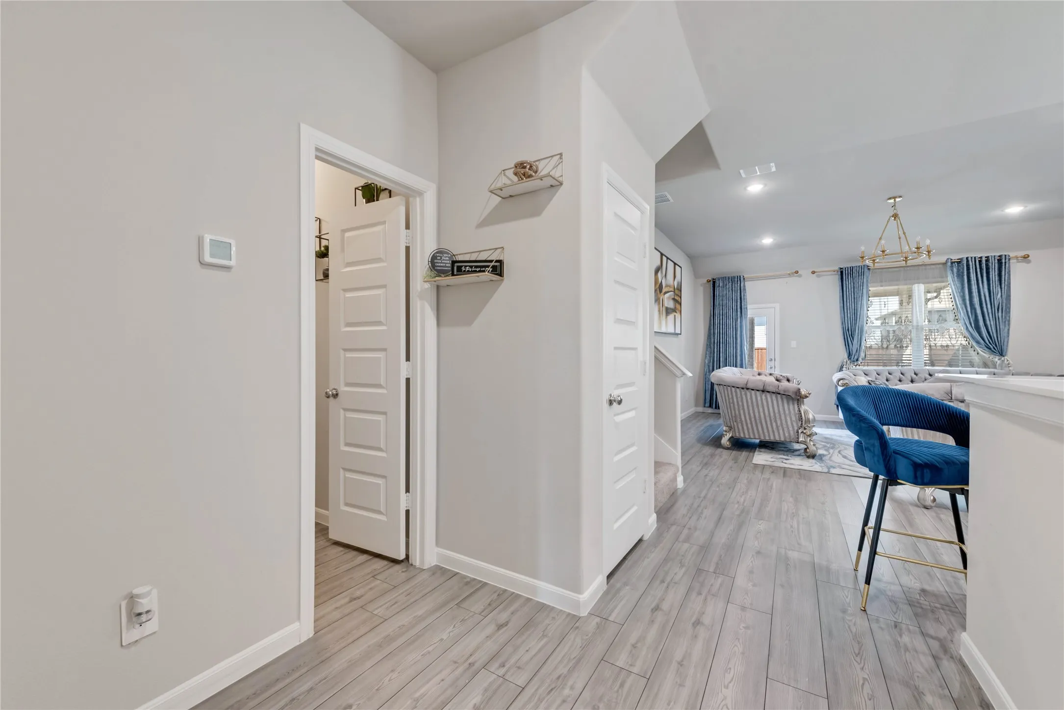 Hallway featuring a chandelier, recessed lighting, light wood-style floors, and baseboards