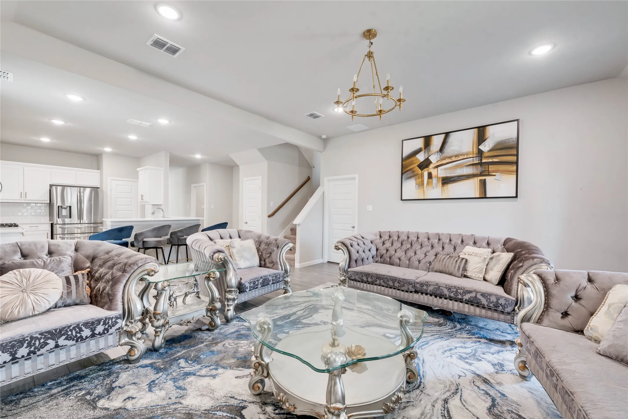 Living area featuring an inviting chandelier, visible vents, recessed lighting, stairs, and light wood finished floors