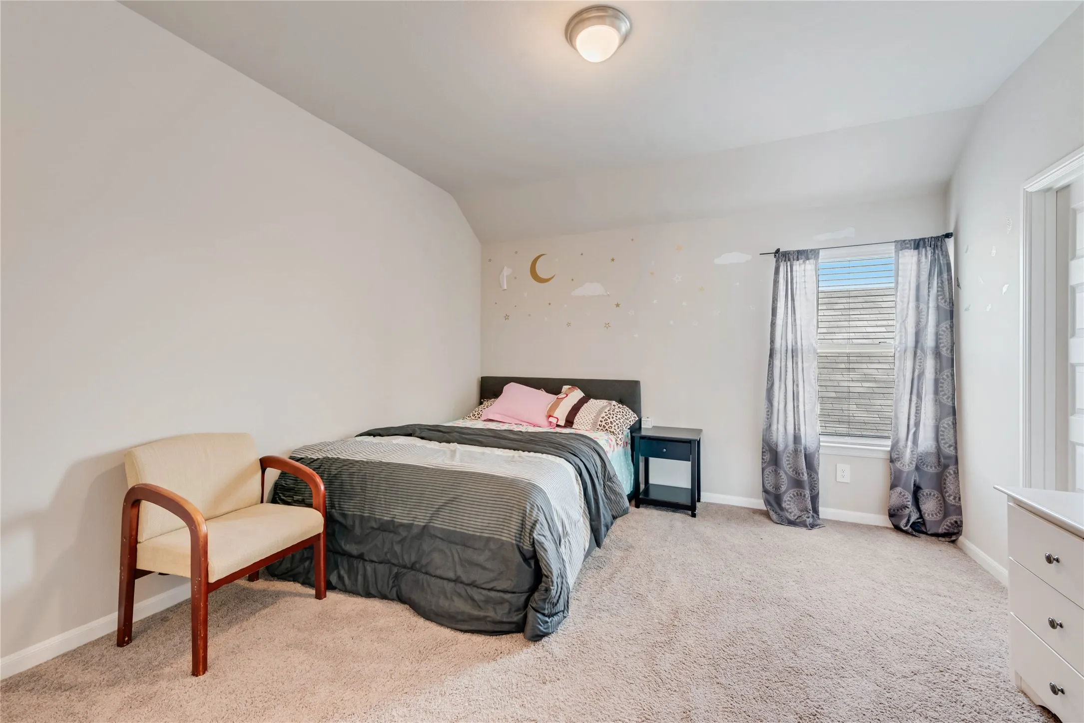 Carpeted bedroom featuring baseboards and vaulted ceiling