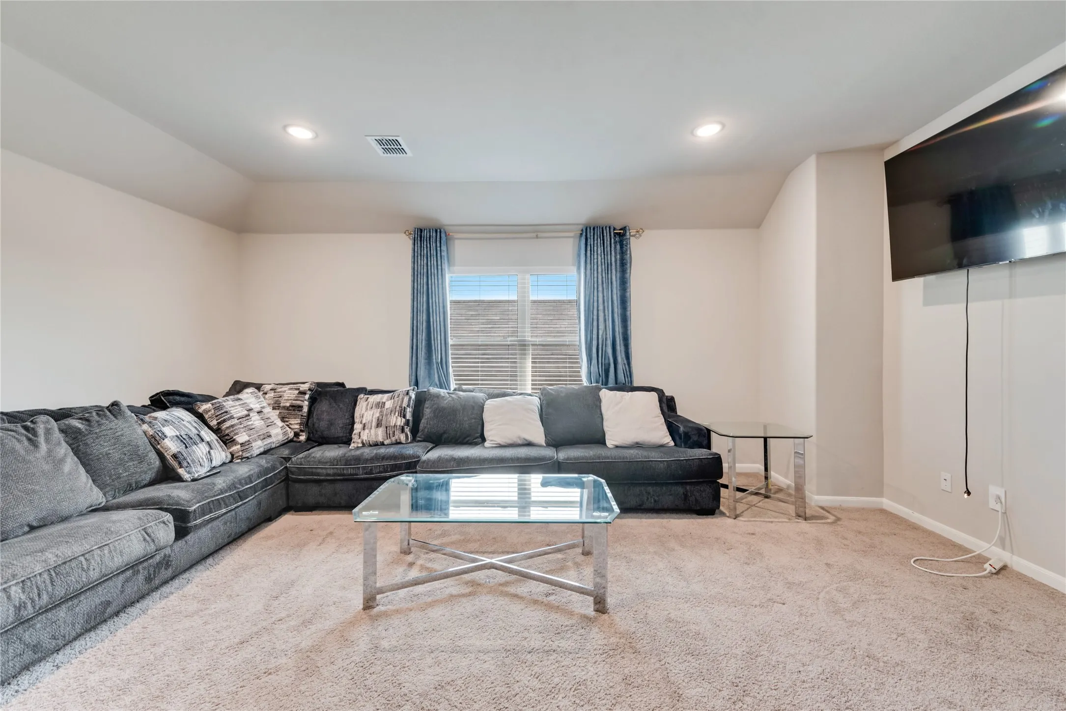 Living area featuring visible vents, baseboards, recessed lighting, and carpet floors