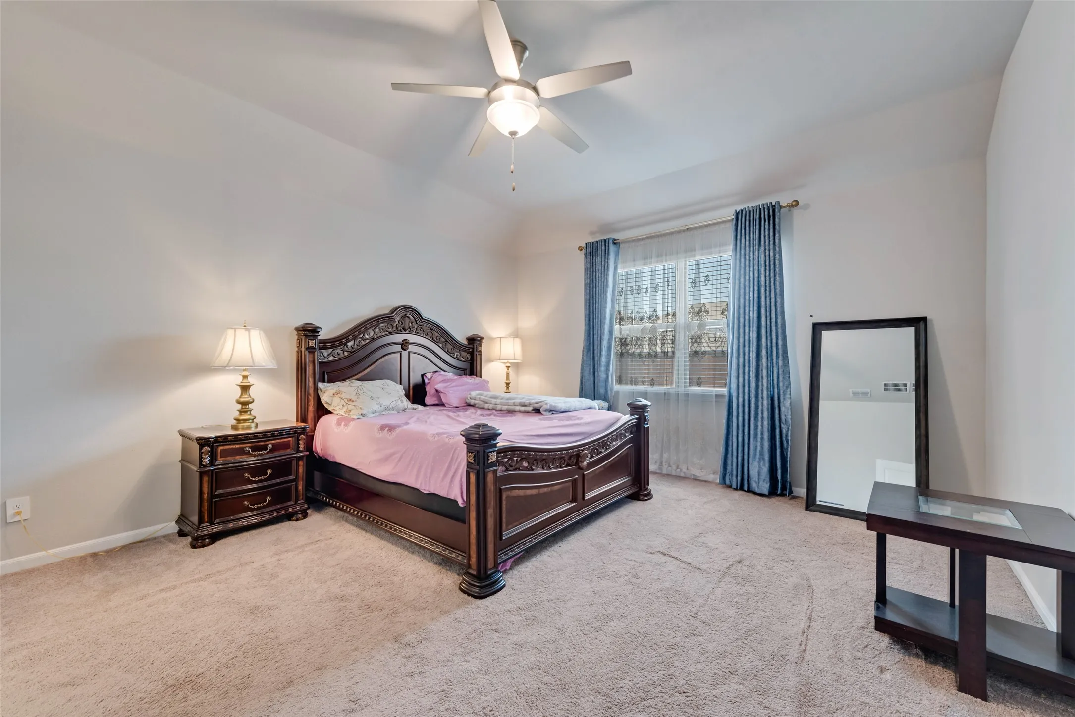 Carpeted bedroom with baseboards and a ceiling fan