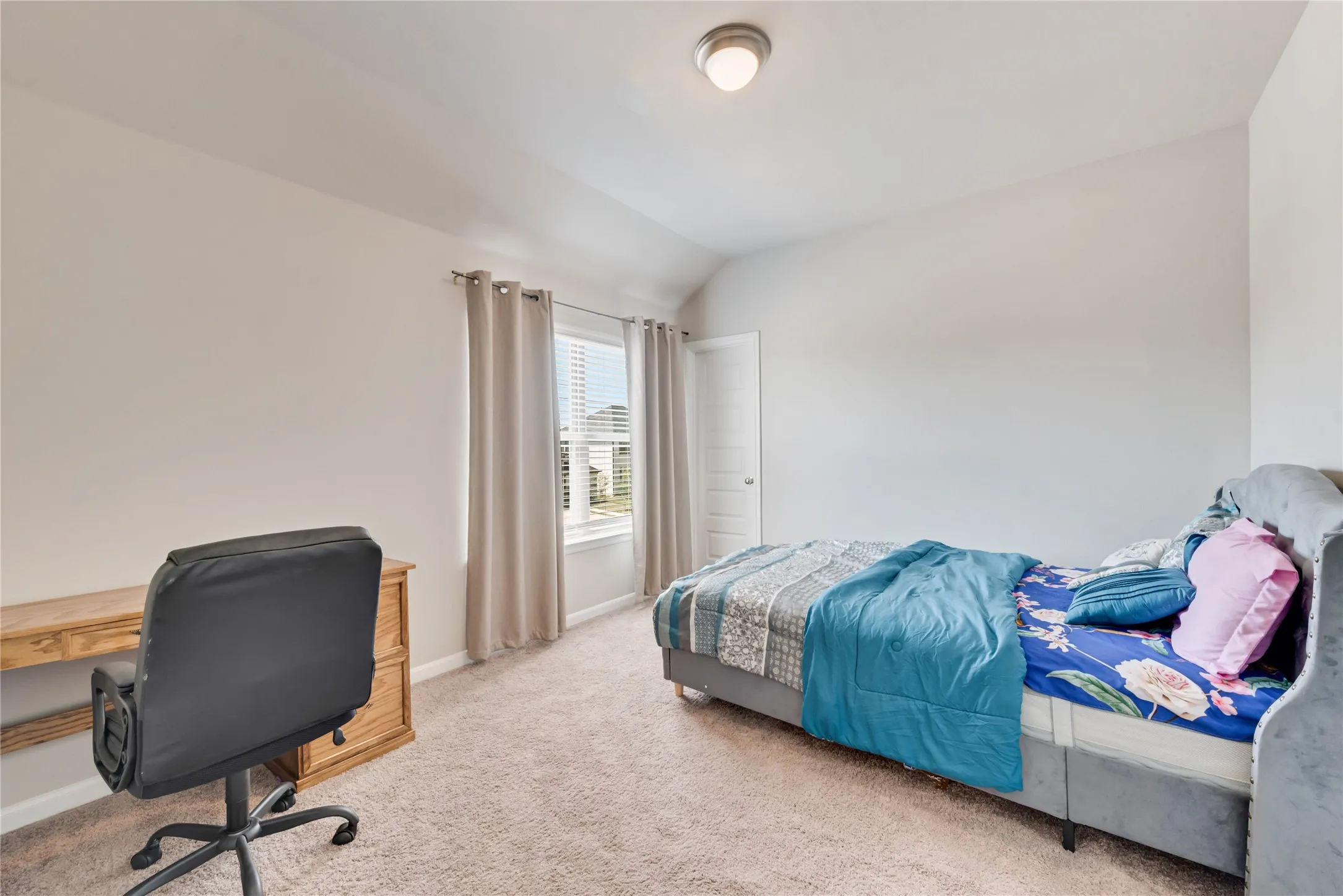 Carpeted bedroom featuring baseboards and lofted ceiling