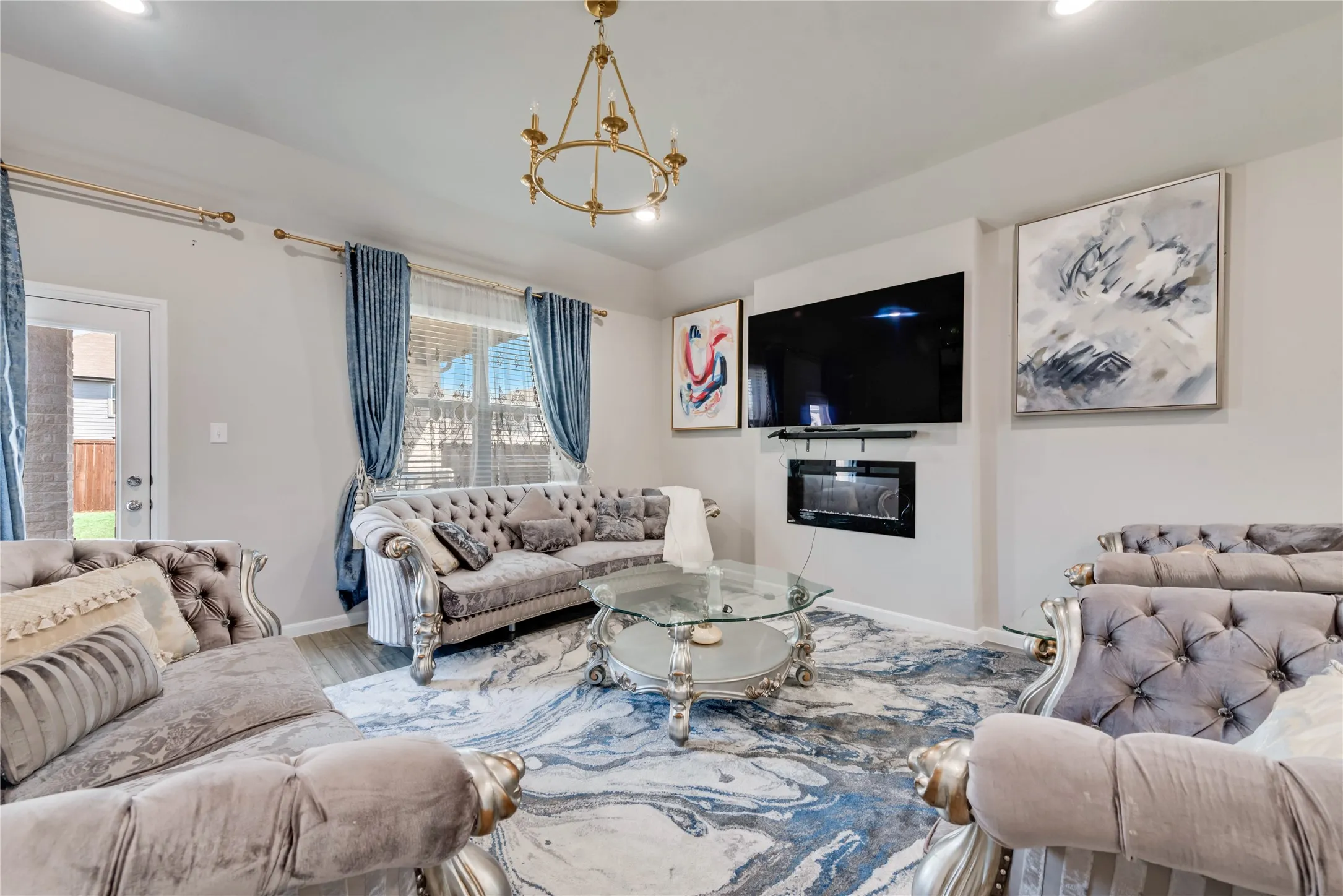 Living room featuring wood finished floors, an inviting chandelier, baseboards, and recessed lighting