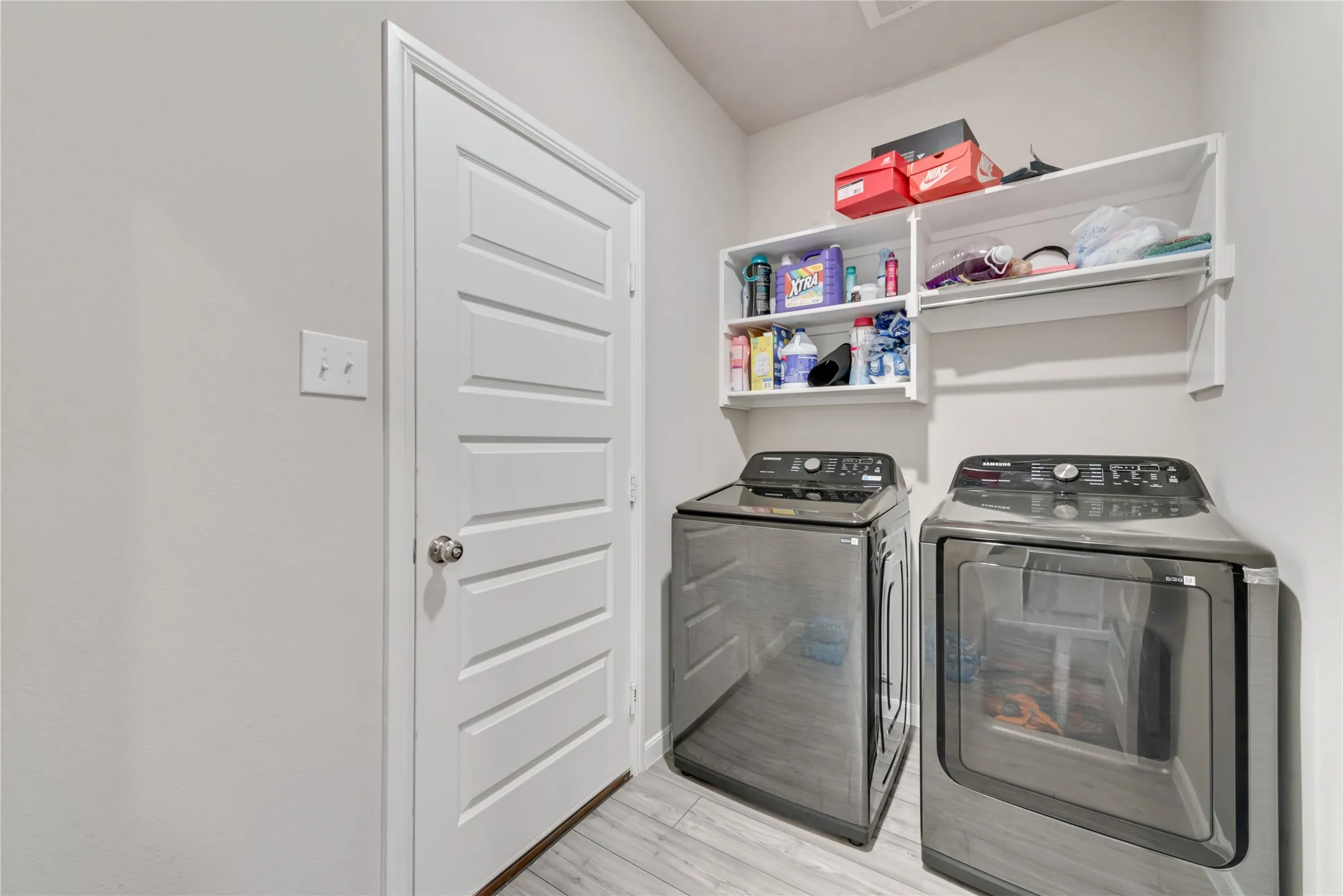 Laundry room with laundry area, separate washer and dryer, and light wood-style floors