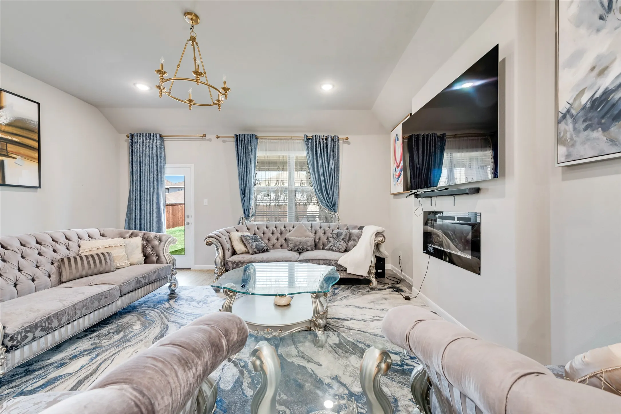 Living area with recessed lighting, baseboards, an inviting chandelier, and lofted ceiling