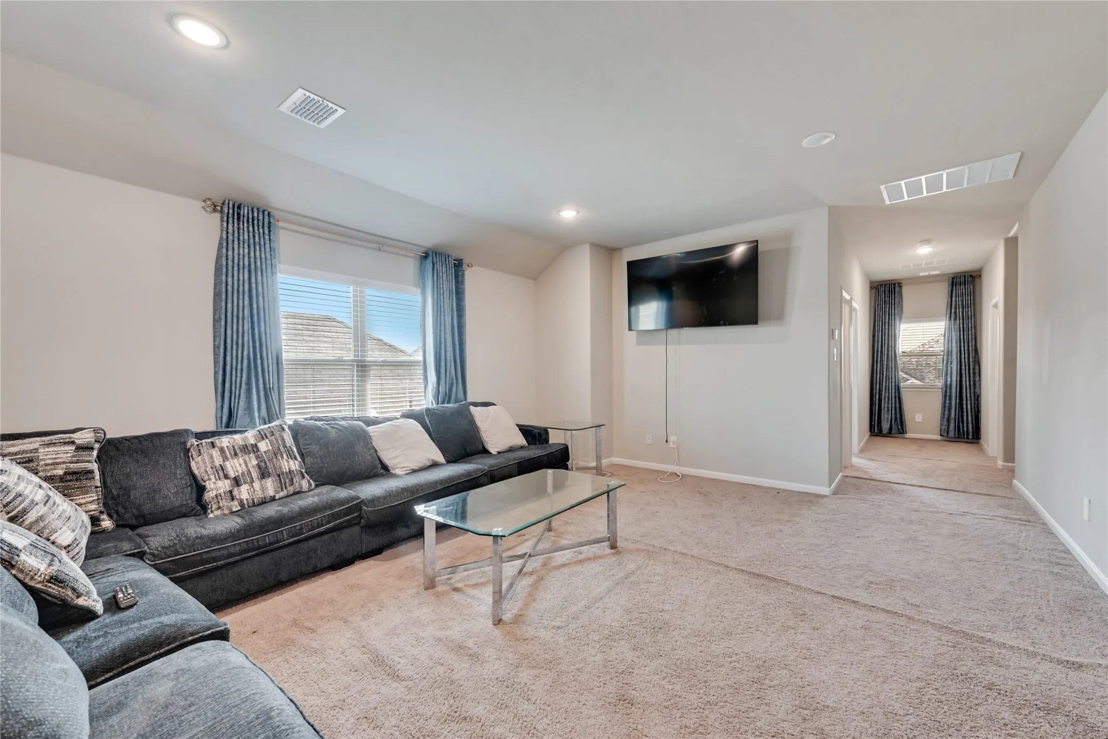Living room featuring a healthy amount of sunlight, carpet flooring, and visible vents