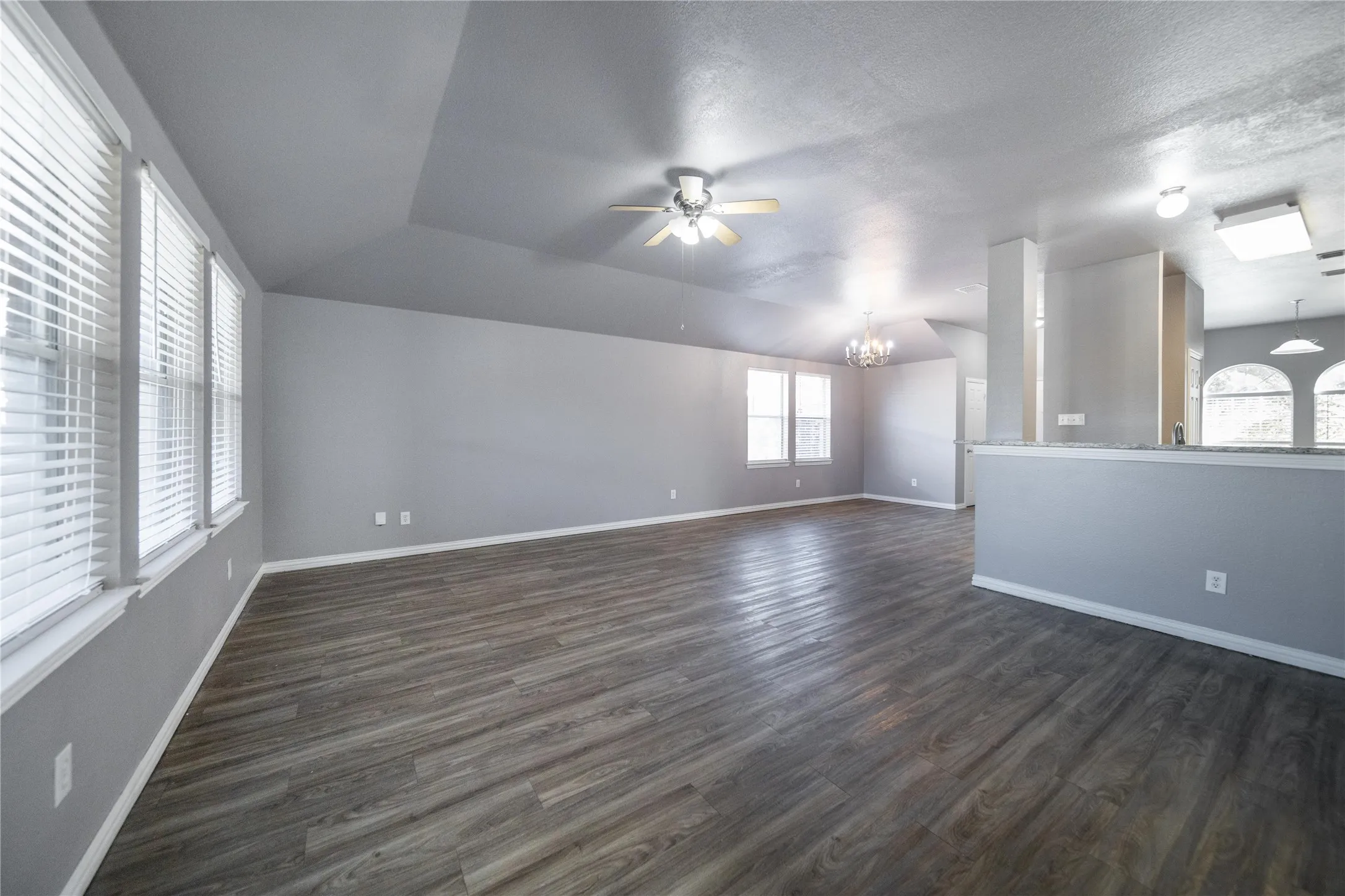 Spacious interior featuring wood-finish flooring, vaulted ceilings, and extensive window light