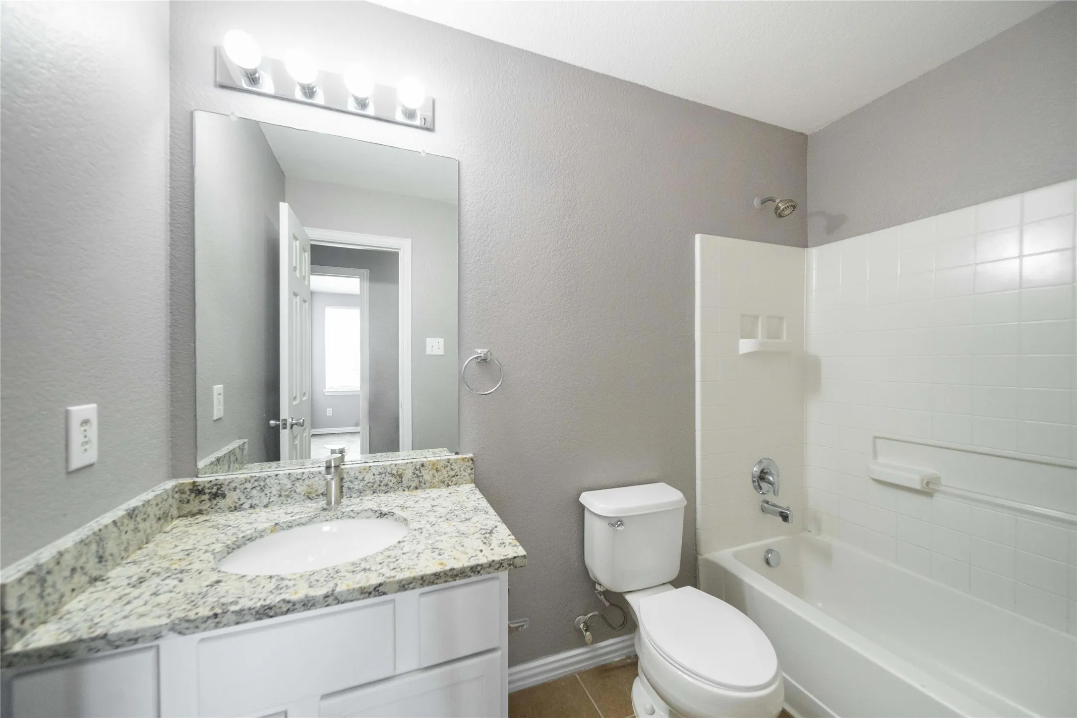 Bathroom featuring a white vanity with a light granite-style countertop, an undermount sink, and a chrome faucet