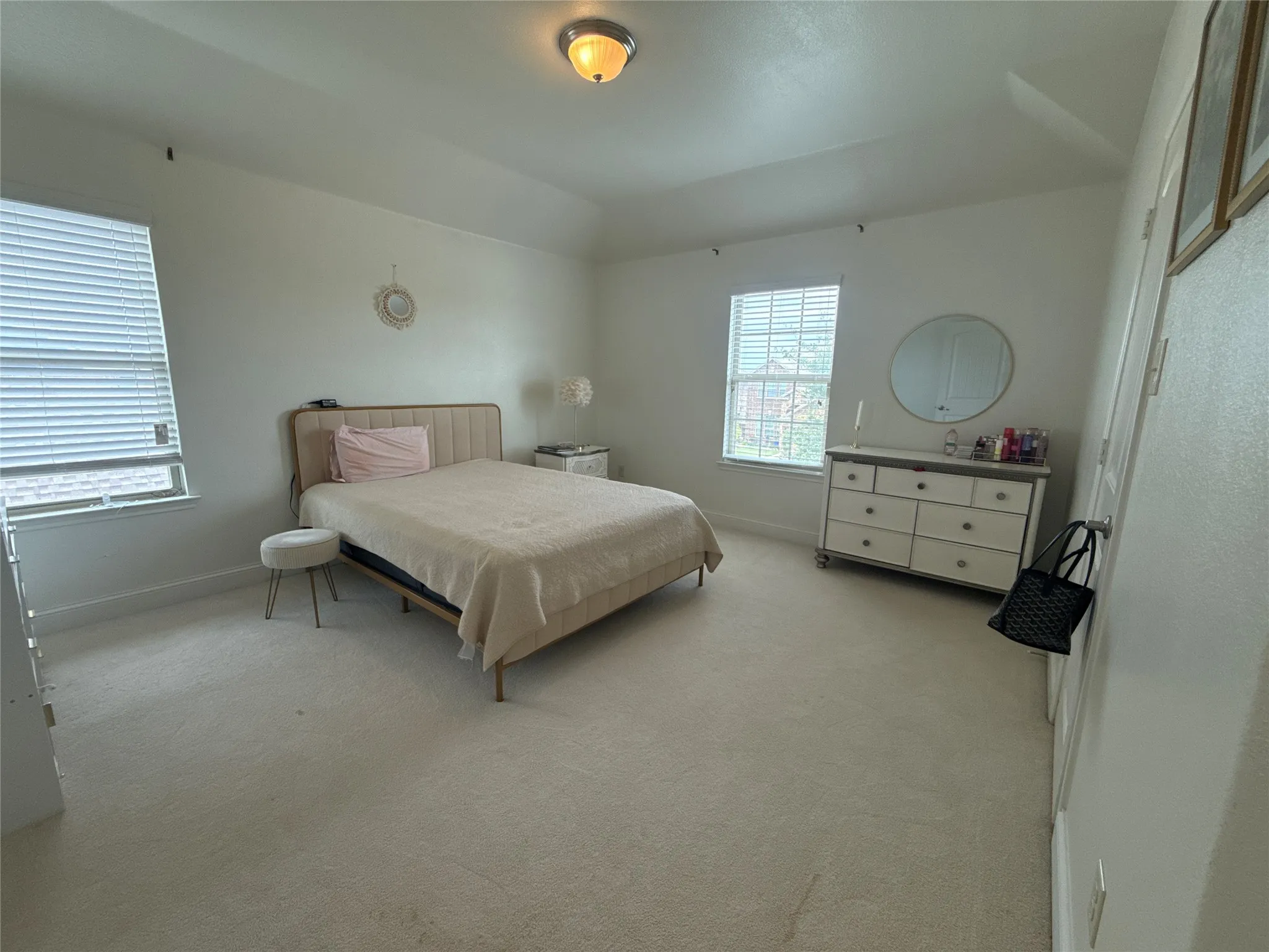 Carpeted room featuring a vaulted ceiling and two windows with blinds