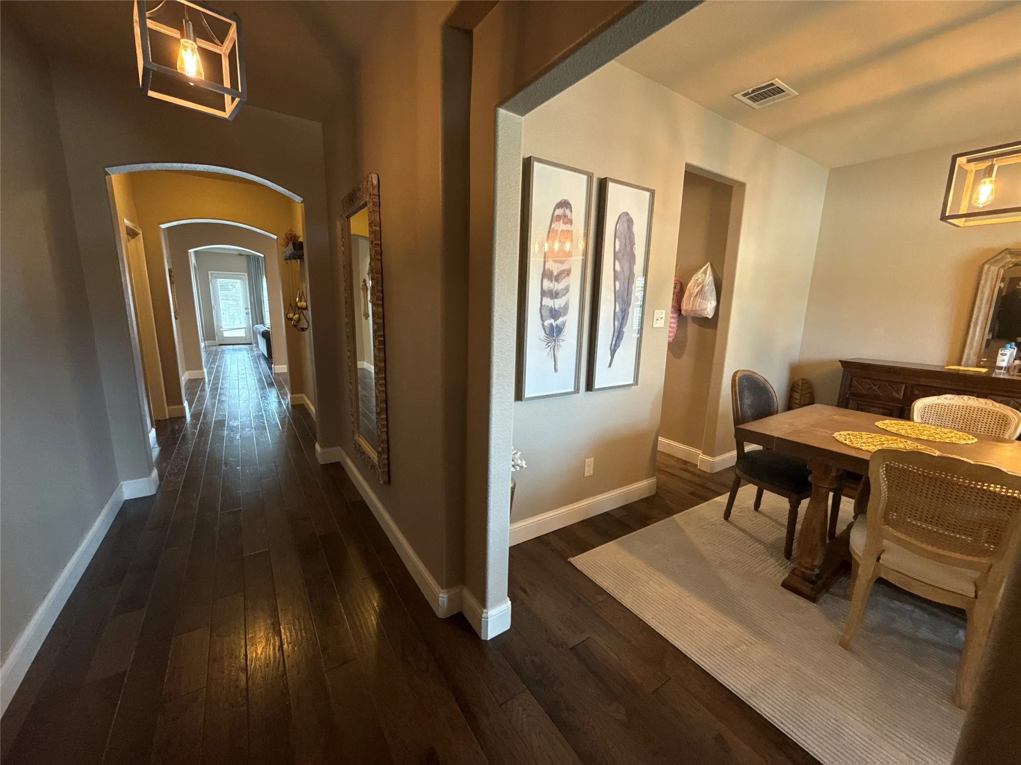 Entryway featuring dark wood-finish flooring, white baseboards, and arched doorways