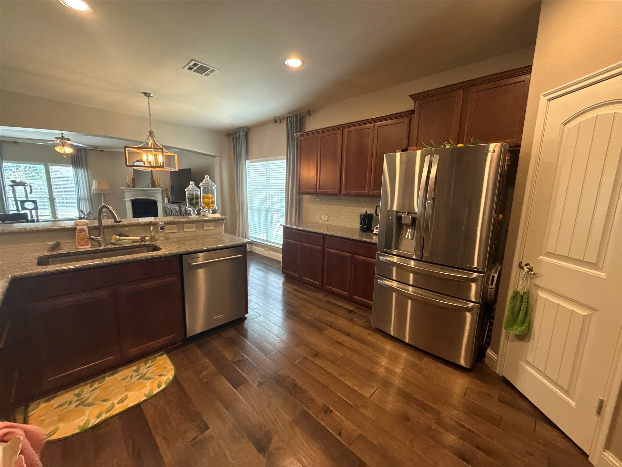 Kitchen featuring wood-finish flooring and rich wood cabinetry