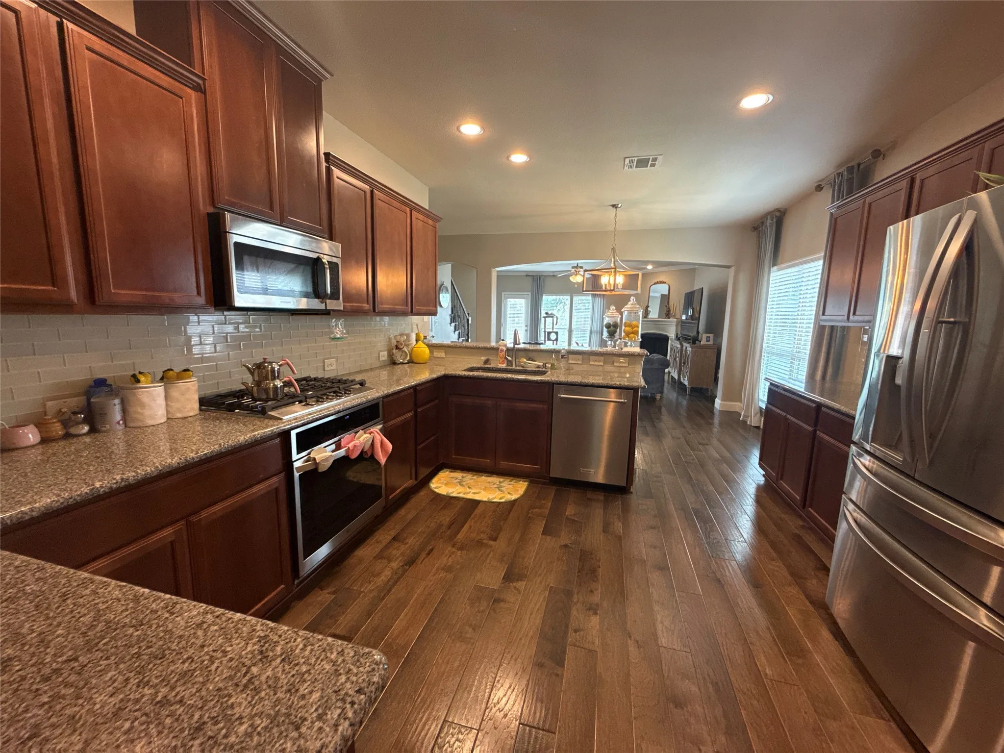 Kitchen featuring wood-finish flooring, recessed lighting, and rich wood cabinetry