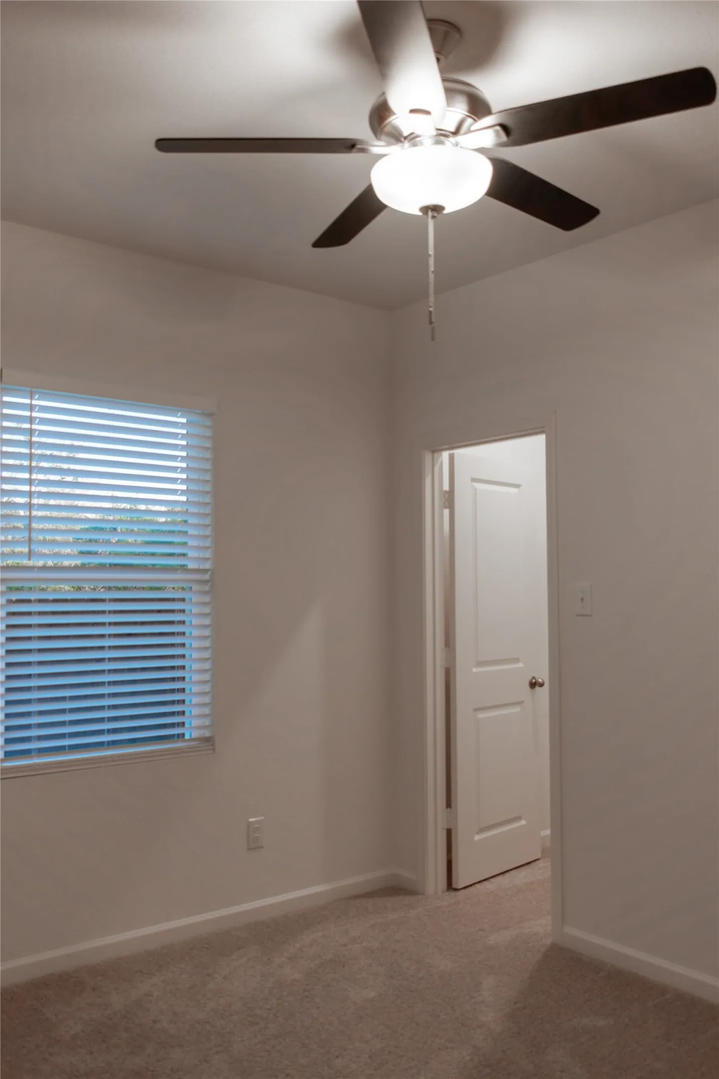 Spare room featuring carpet floors and ceiling fan