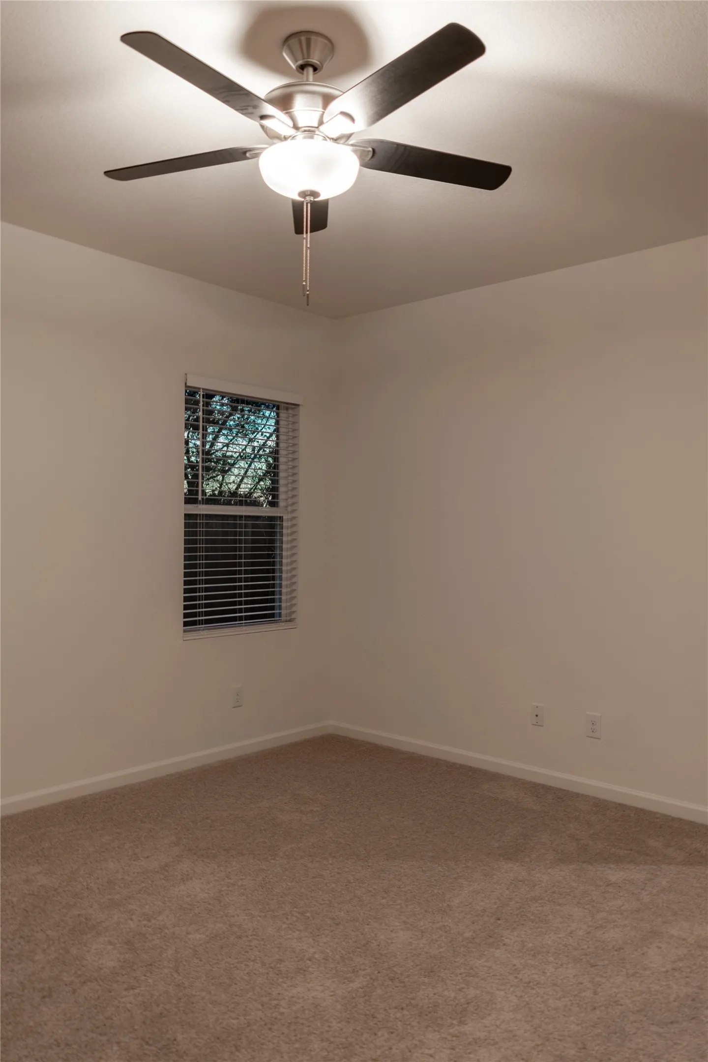 Carpeted empty room with ceiling fan