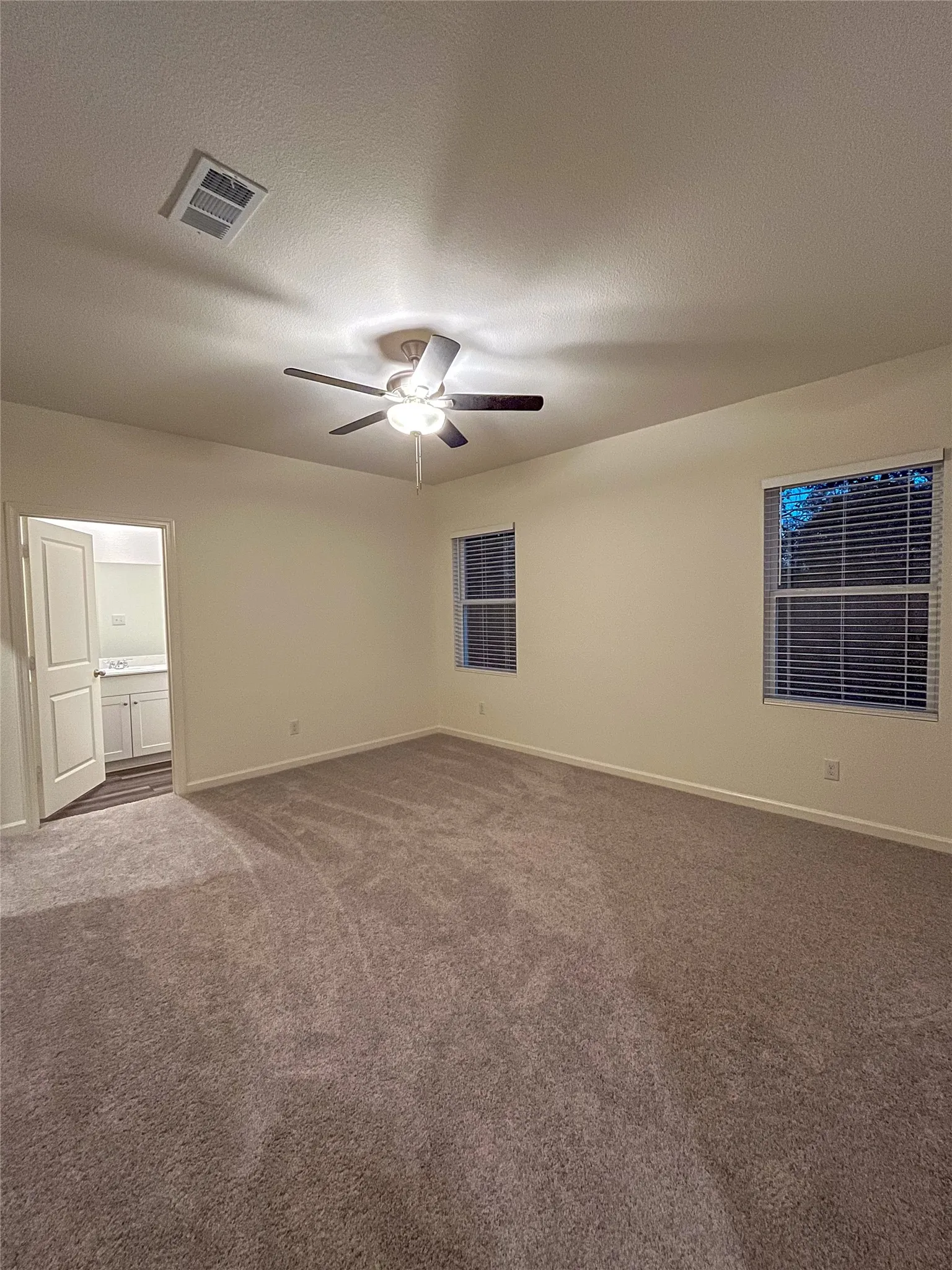 Carpeted spare room with ceiling fan and a textured ceiling