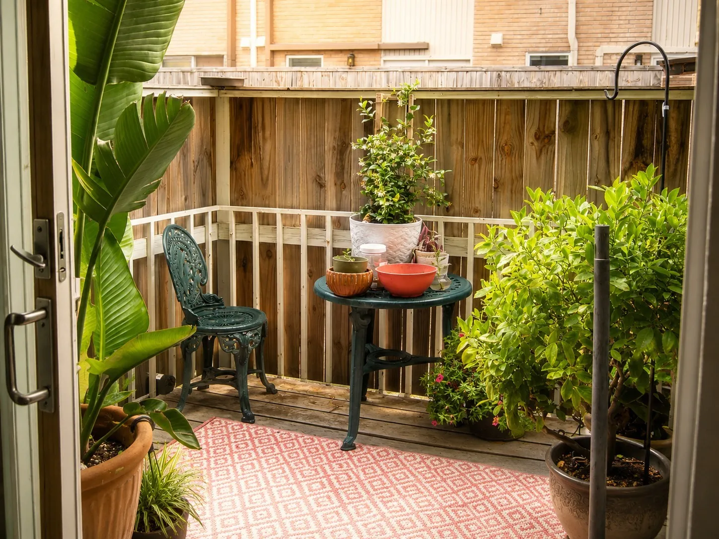 Private outdoor patio featuring wood-finish flooring, a wood privacy fence, and a white railing