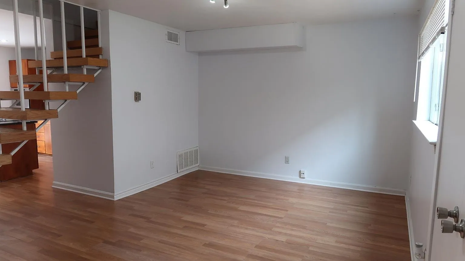 Open-concept living area with wood-finish flooring