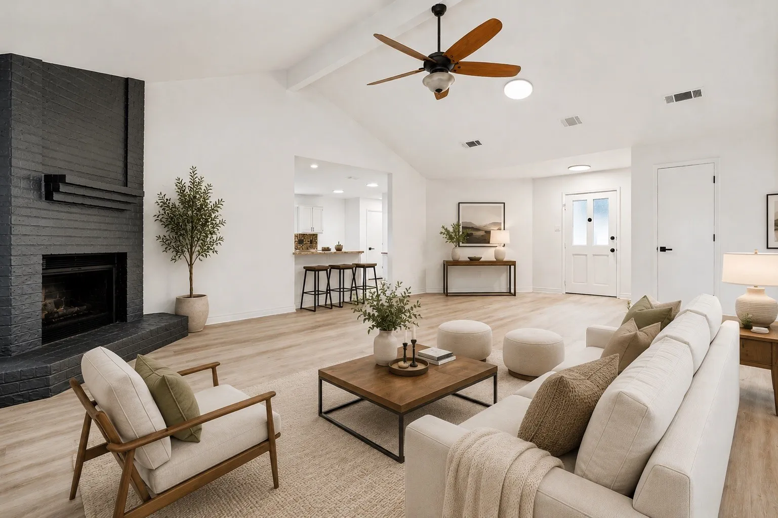 Spacious living area featuring a vaulted ceiling with exposed beams, a ceiling fan, and wood-finish flooring