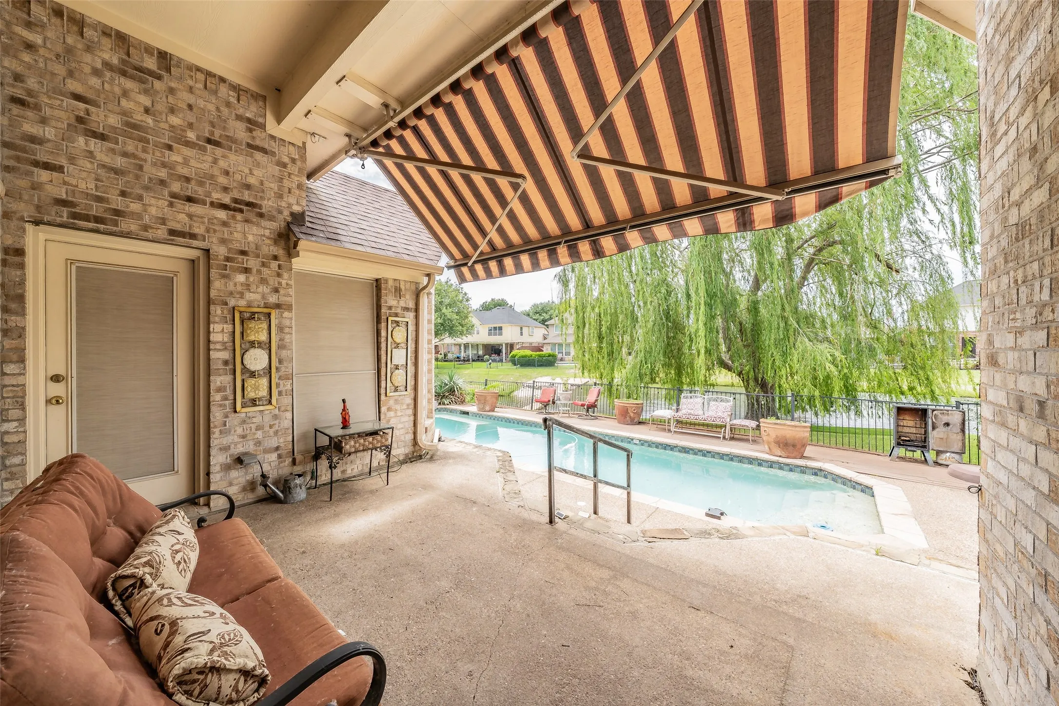 Covered patio with awning - view of pool and canal