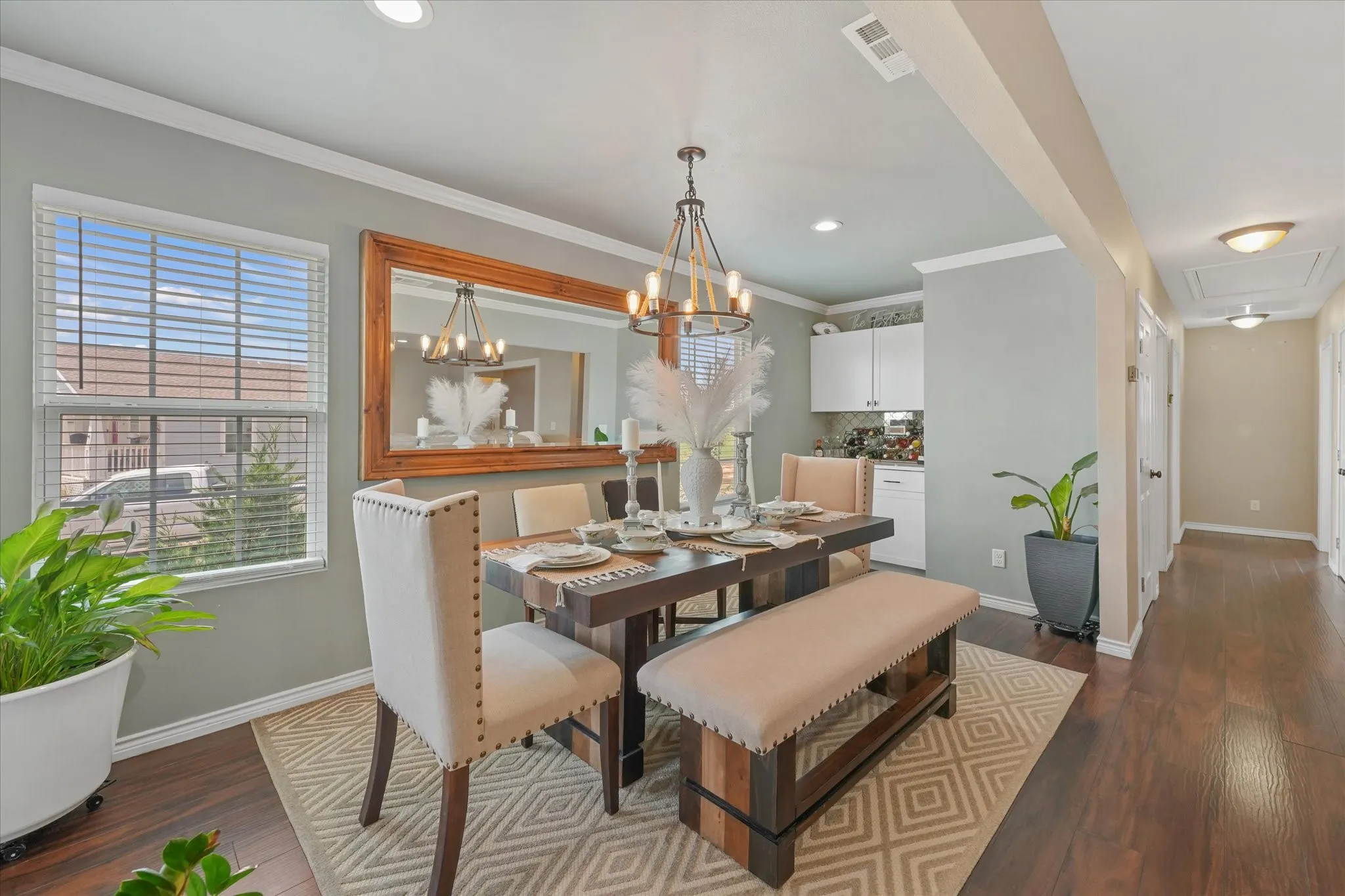 Dining area featuring wood-finish flooring, a large framed mirror, recessed lighting, and a contemporary chandelier