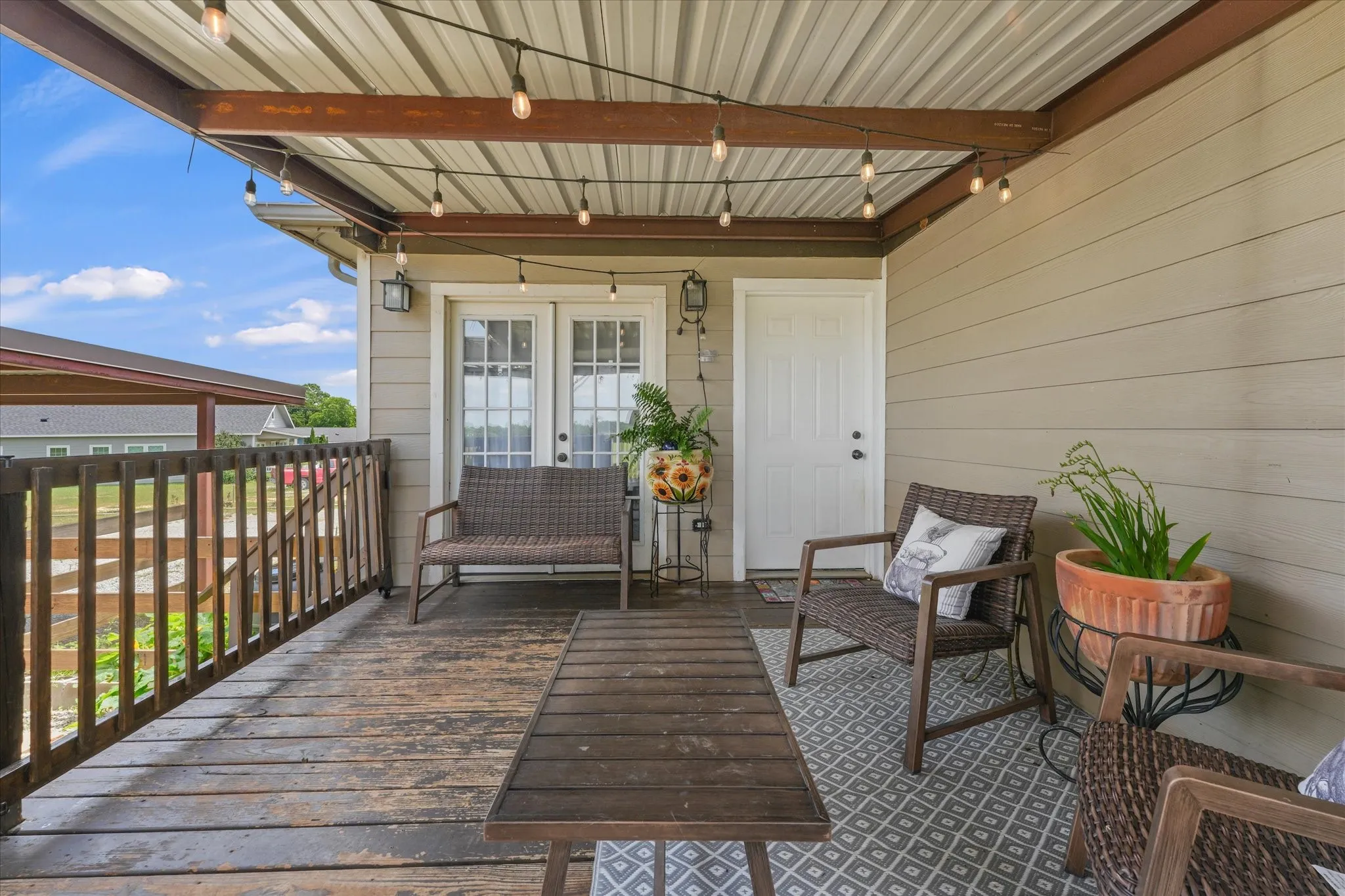 Covered outdoor deck with exposed wood plank flooring