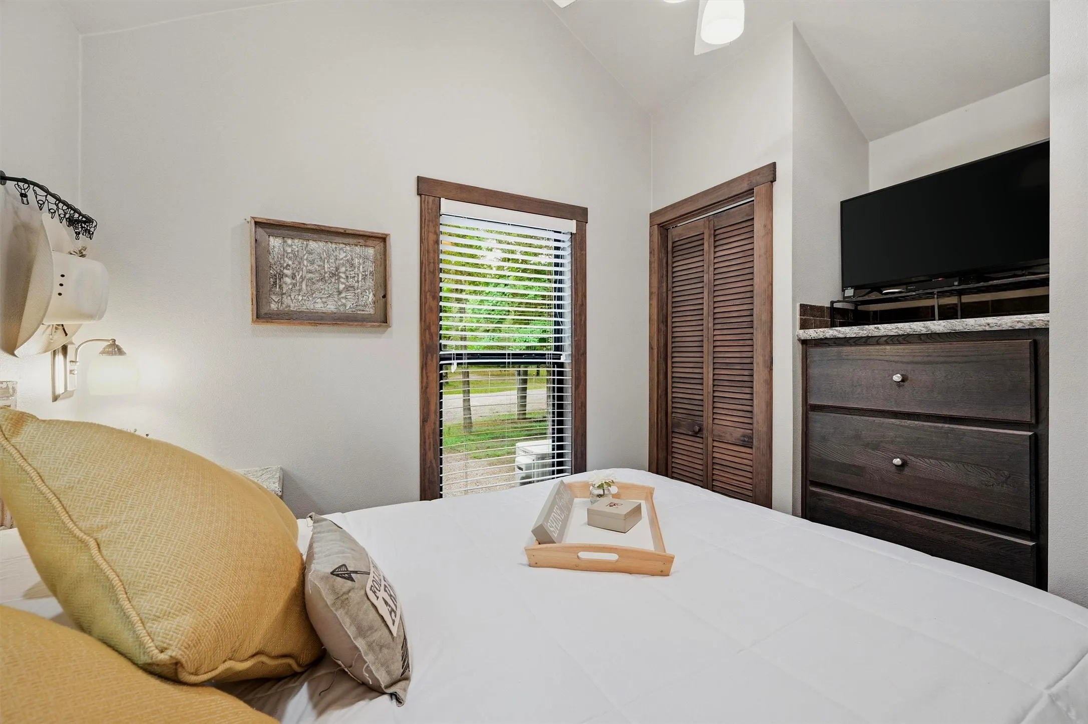 Bedroom with a window featuring horizontal blinds and wood trim