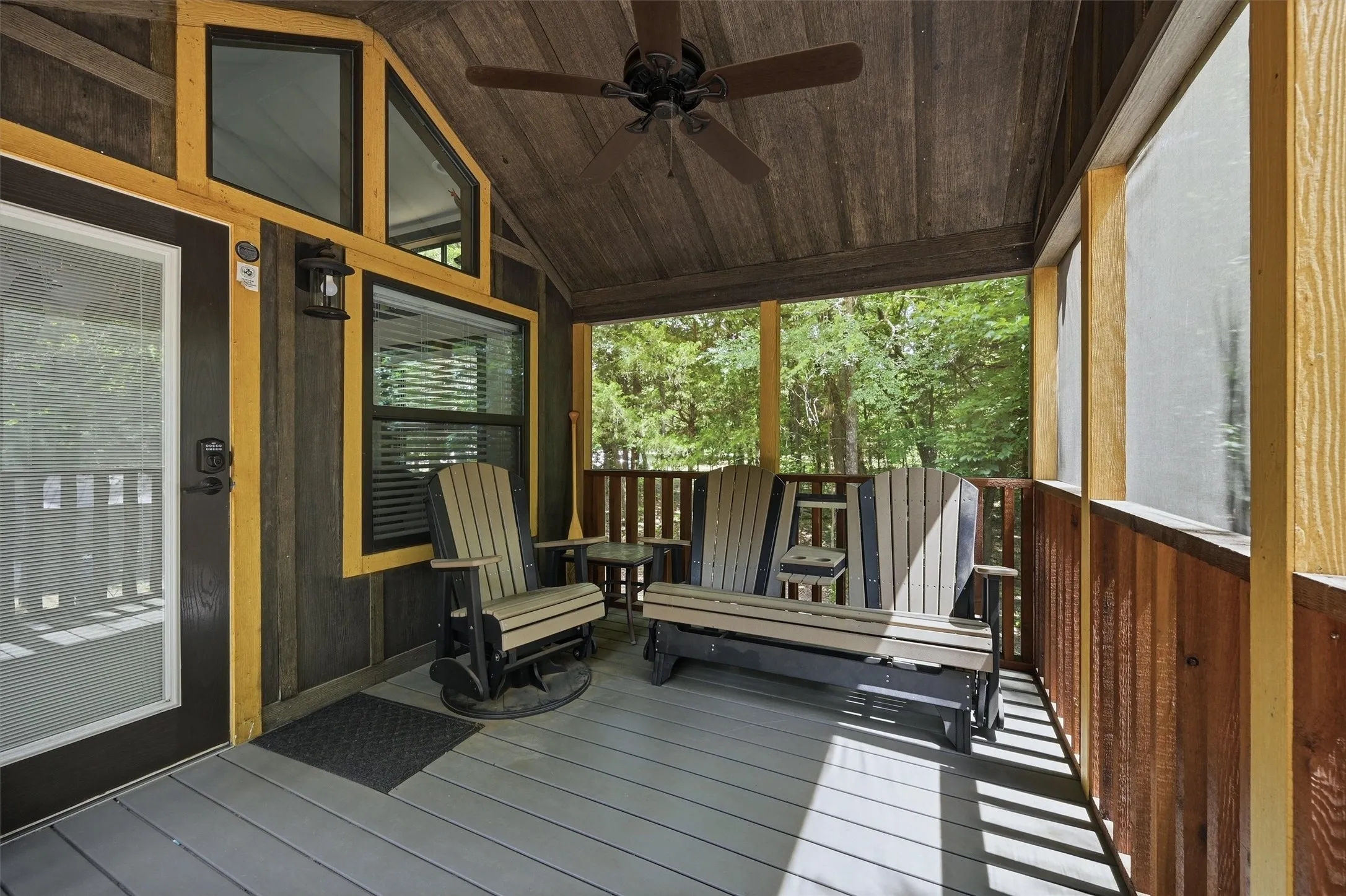 Screened porch with wood-finish flooring, wood plank ceiling, exposed wood beams, and a ceiling fan