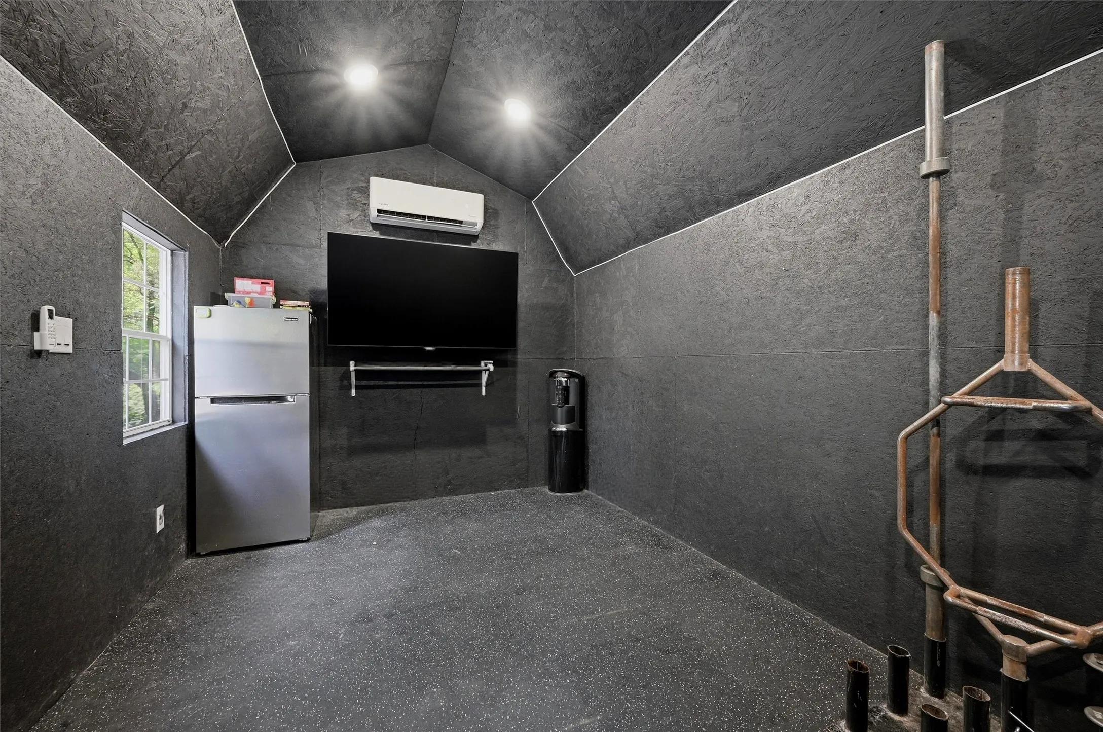space featuring dark textured wall and ceiling finishes, recessed lighting, and rubber flooring
