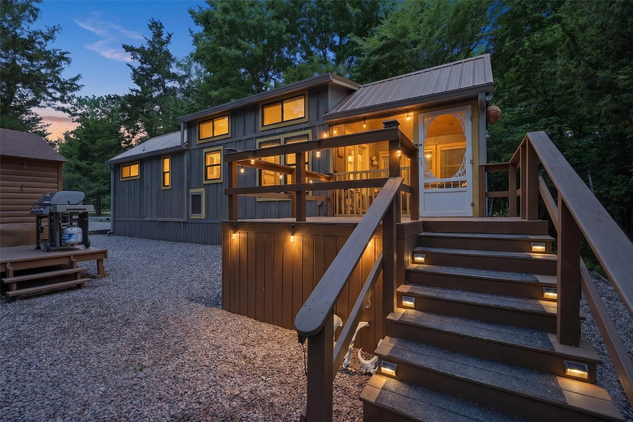 Exterior featuring a corrugated metal roof, wood siding, and multiple windows