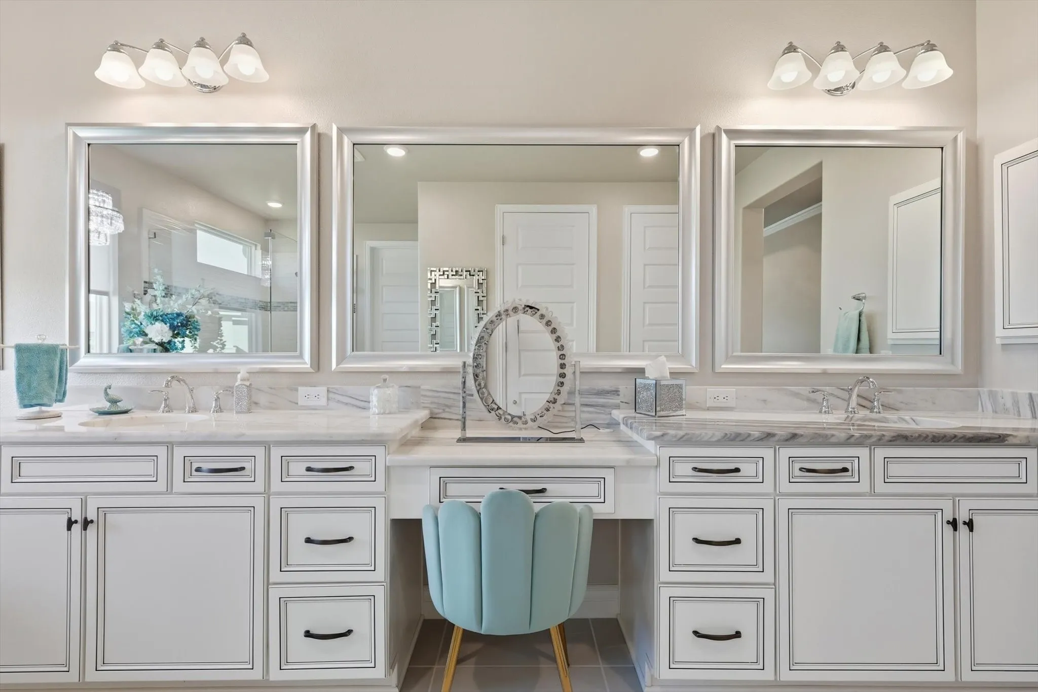 Dual vanity with white cabinetry, framed mirrors, and chrome hardware