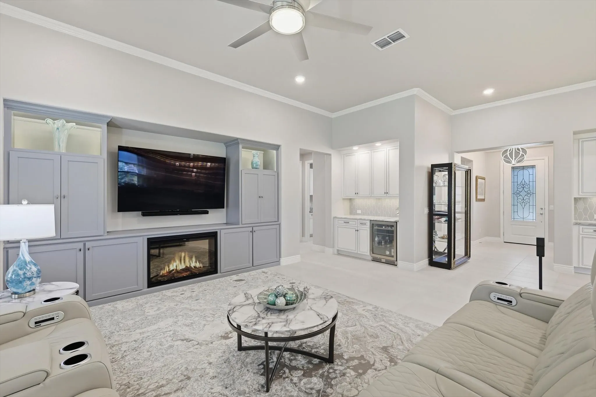 Living area featuring a built-in entertainment center with a fireplace, vaulted ceilings, and crown molding