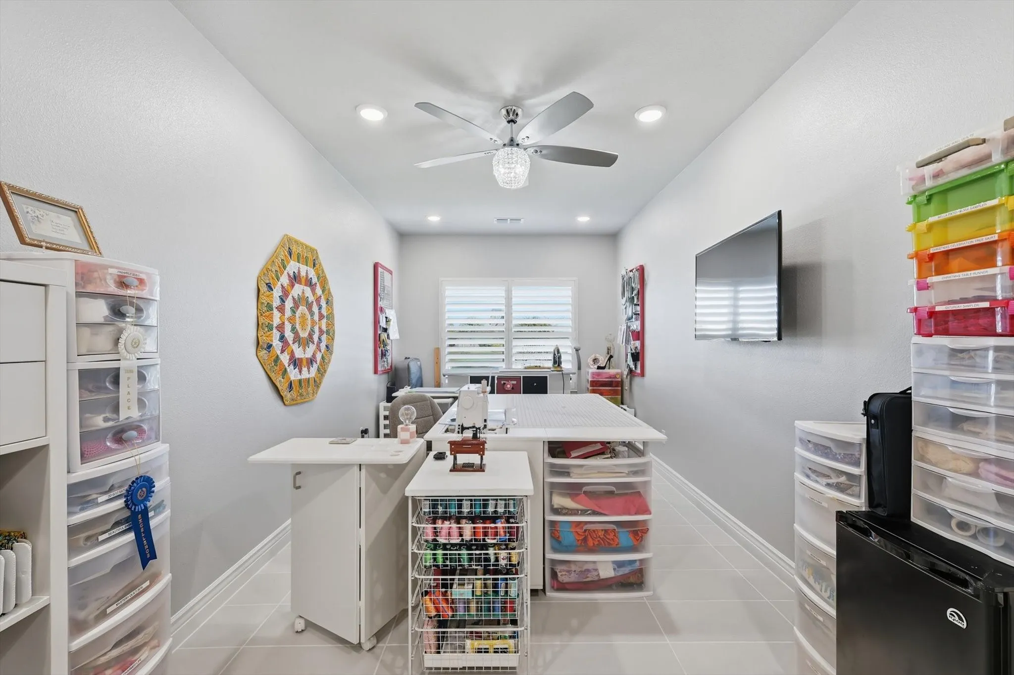 Spacious room featuring light gray walls, recessed lighting, a ceiling fan, and large format tile flooring